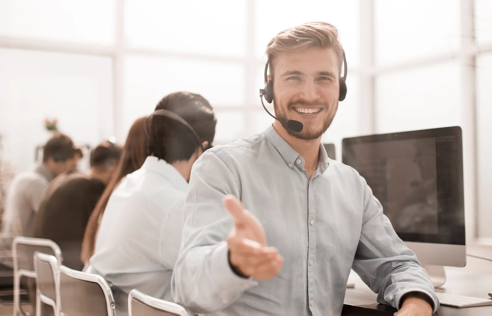 A smiling call center agent greets a customer.