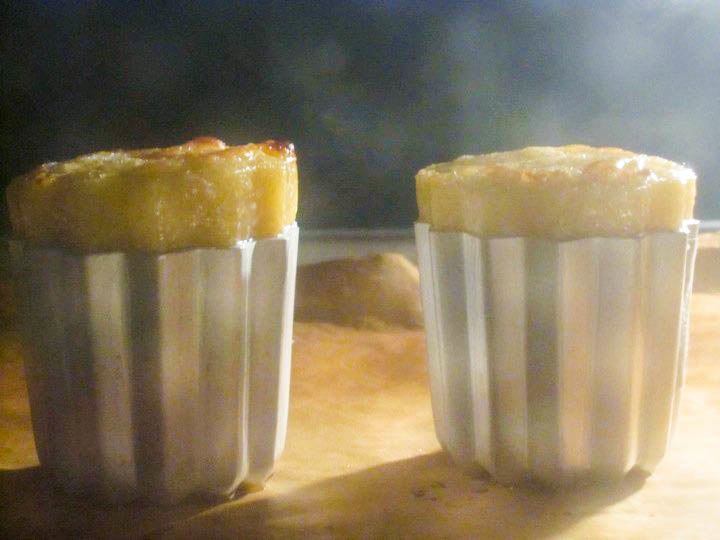 Caneles just beginning to rise in the oven