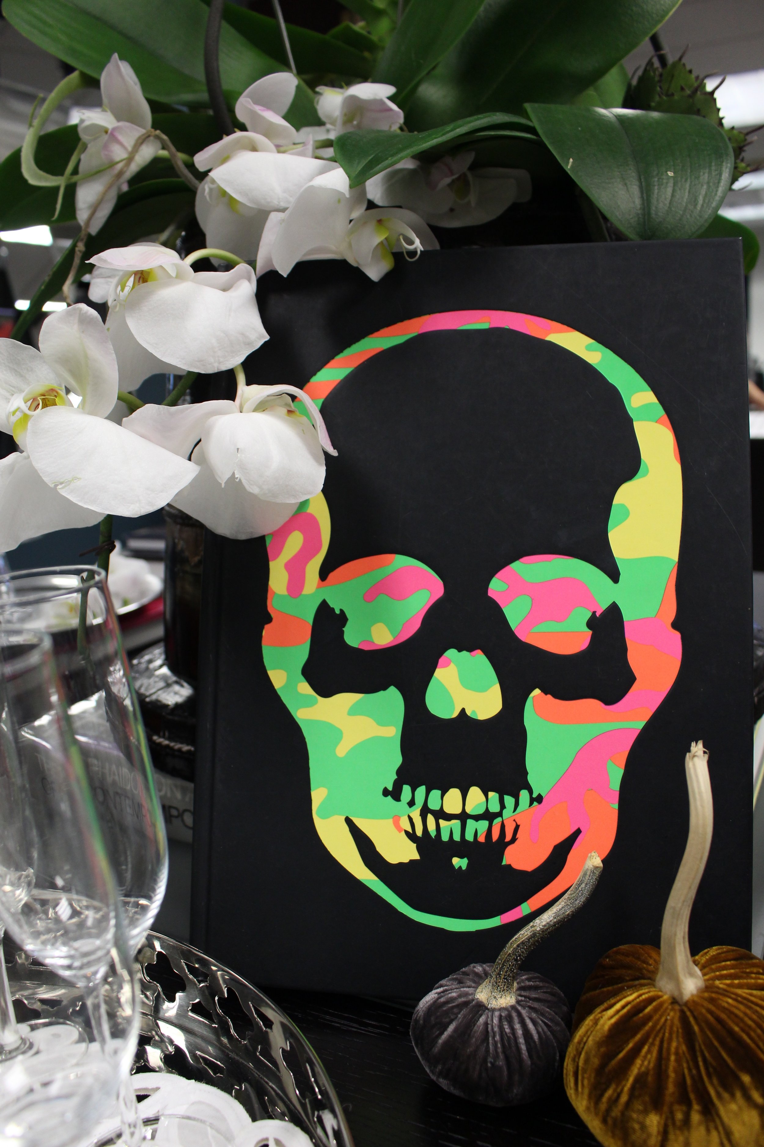 Neon skulls, velvet pumpkins and fresh white orchids provide the perfect party décor