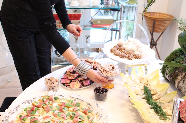 Jessica arranges the food and lights candles wearing a stack of silver All Weather Bangles . 