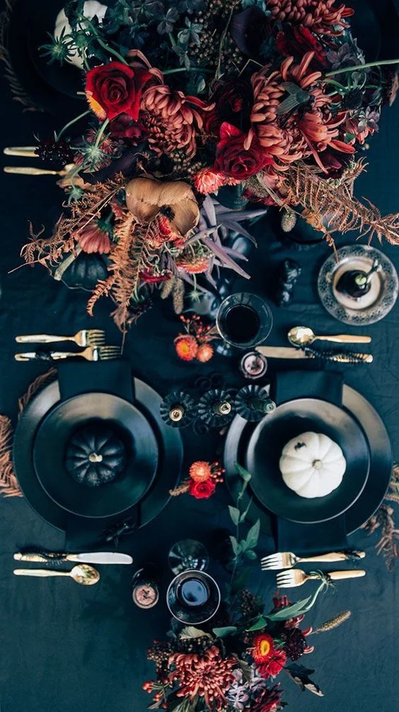 A table setting with black textiles and plates offers the perfect backdrop for bright, bold flower arrangements.