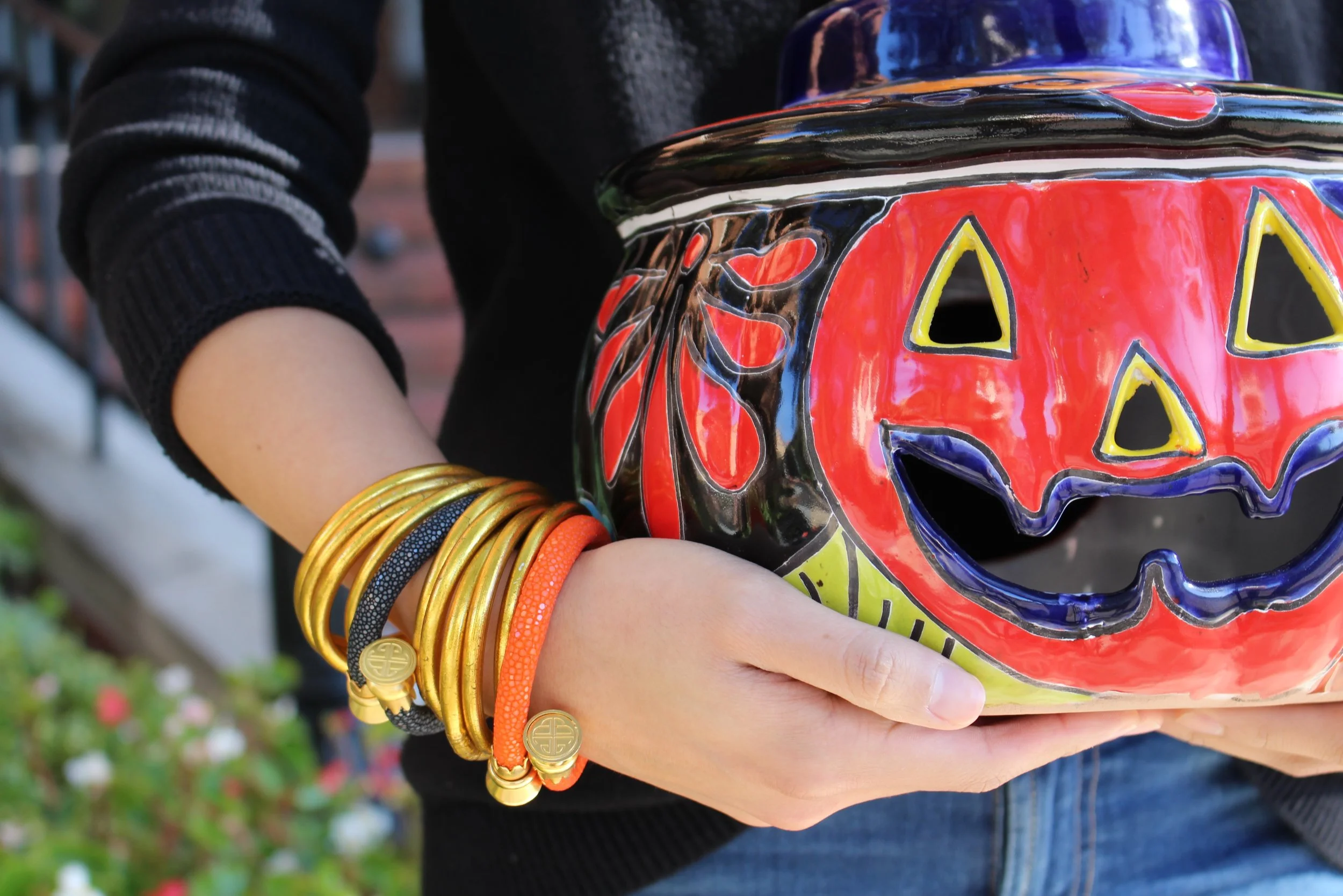 Beautiful, painted ceramic jack o'lantern paired with orange and black Stingray Wrist Wraps .