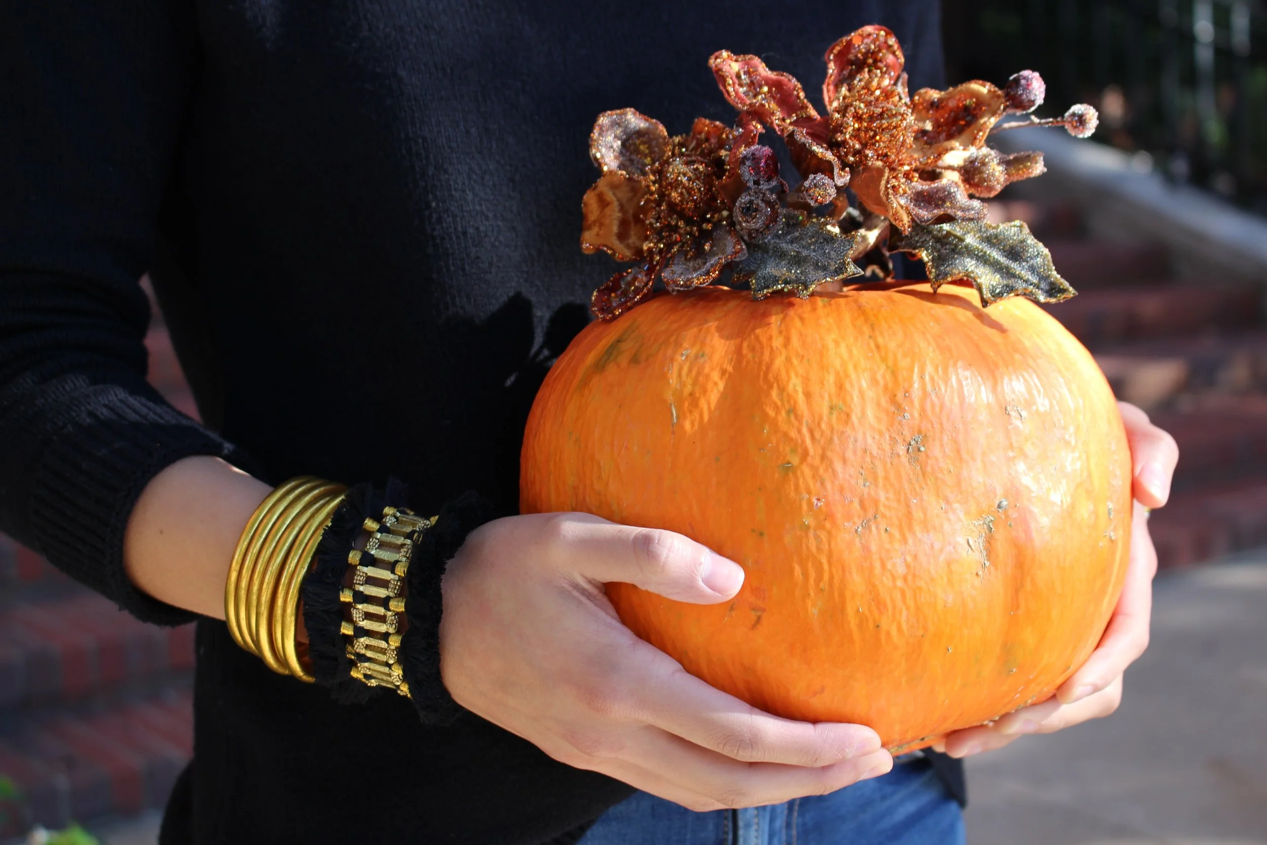 A classic, orange pumpkin crowned with embellished, autumnal napkin rings and complemented by a festive Fringe Bracelet .