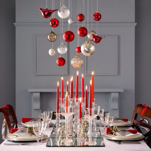 Heighten the visual drama of your table with long, tapered candles and ornaments suspended overhead. 