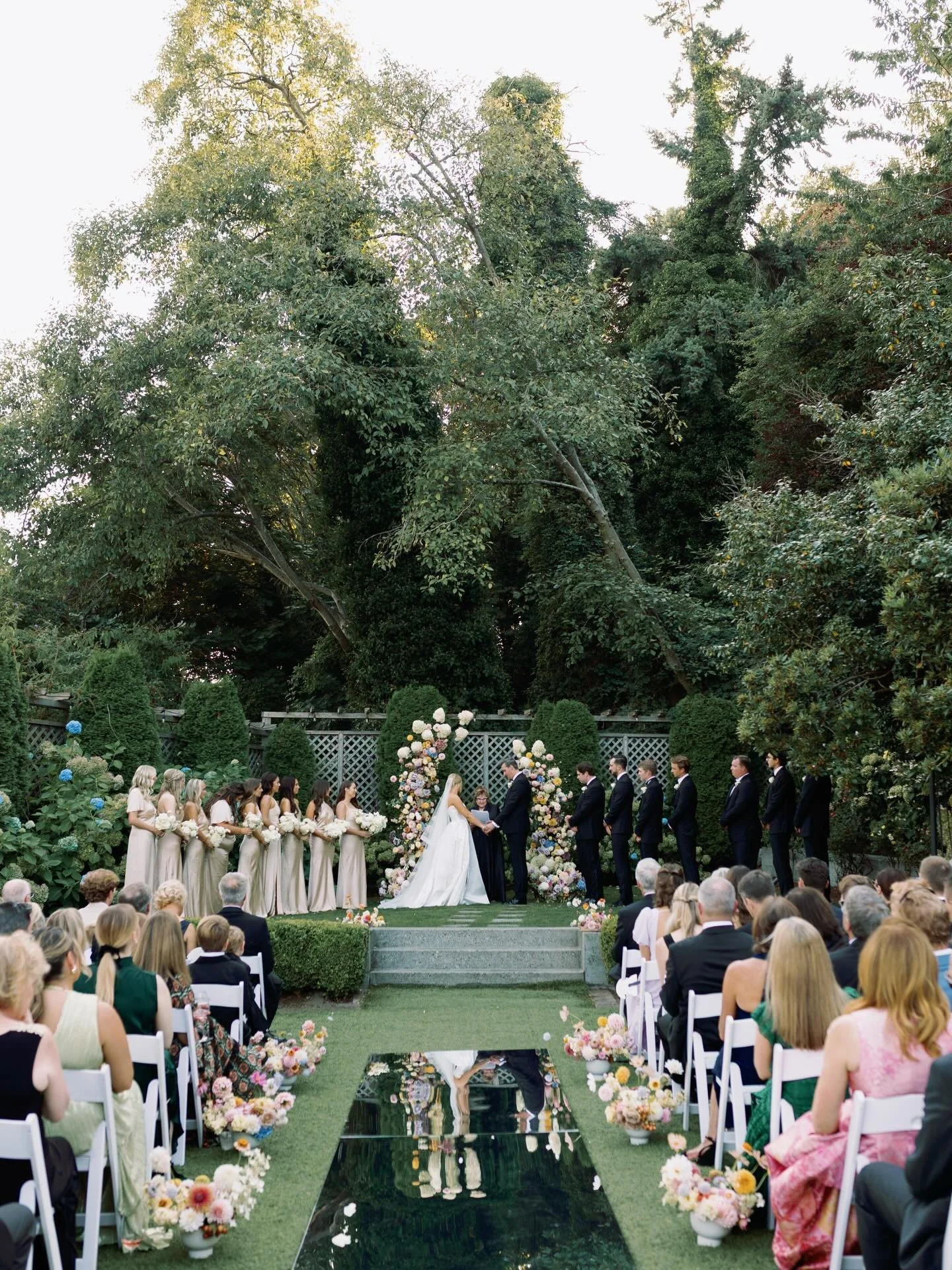 This ceremony was a stunner, with a reflective mirror aisle and cotton candy floral arch. It was also one of my favorite father-of-the-bride moments, swipe to see the emotion as he walks her down the aisle!