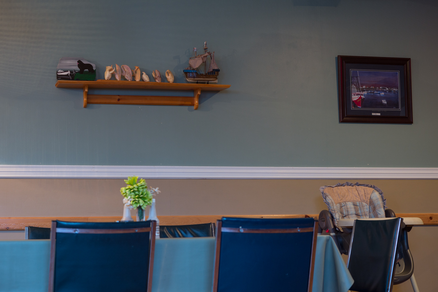 Shelf with painting of Newfoundland dog, crab claws, model ship.