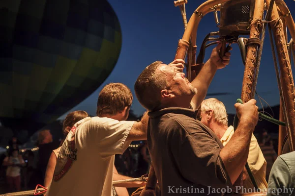 A hot air balloon pilot blows heat into the balloon.