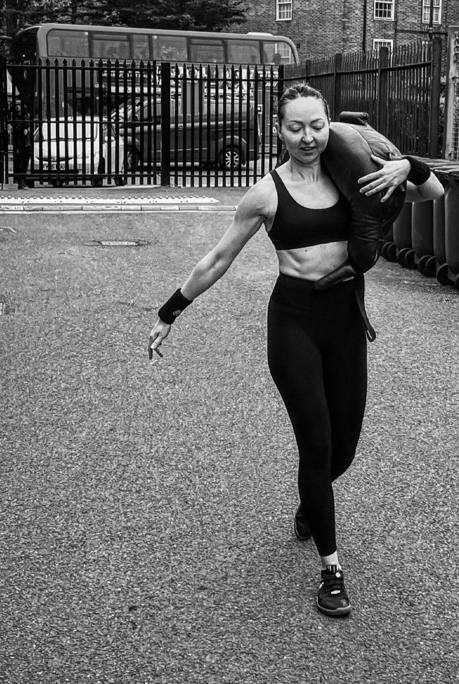 Malika carrying a Bulgarian Bag during strength training at the Commando Temple in Deptford