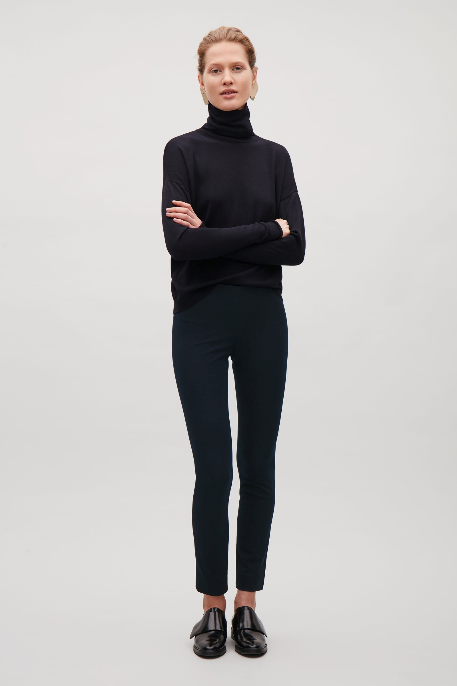 Slim Fit Trousers These trousers have worked well on so many of my clients. I love the quality of the fabric and the fact that they are high-waisted so they really hold you in in all the right places. They are a pretty tight fit - I would definitely suggest going up at least one size. The leg length is pretty long; I would recommend turning them up. They come in both navy and black and each season they introduce new colours. I love the way they are styled in this image. Nailing a simple black look is key for every wardrobe! 