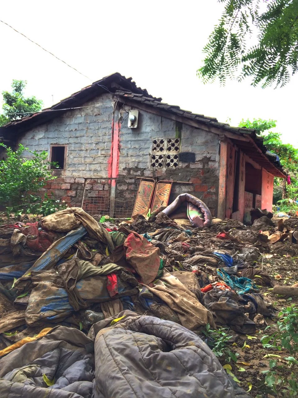 Yards, roads, and gardens are full with debris from the storm. Personal belongings are left muddied and scattered.