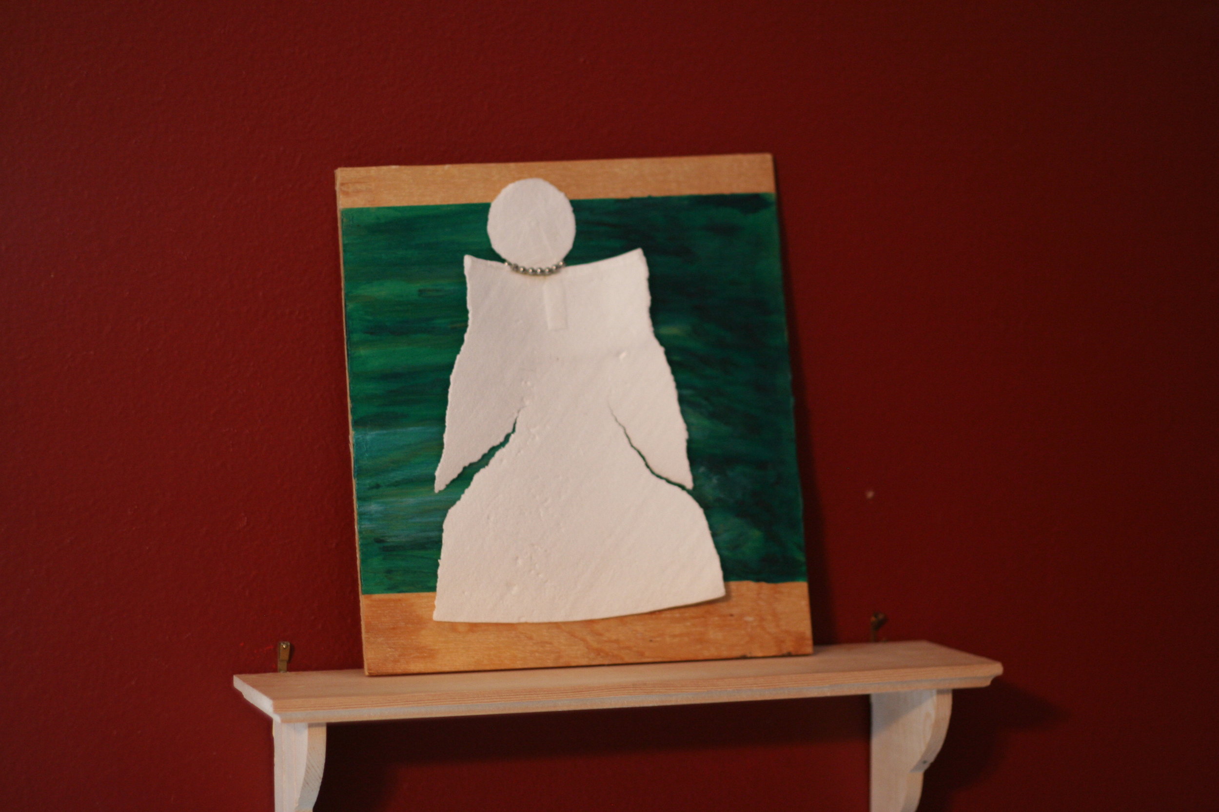 The Art: a styrofoam cup that was run-over. Reminded me of an angel. So I glued the cup, unchanged, to a painted board and added a necklace. I guess I made this back in 2010?