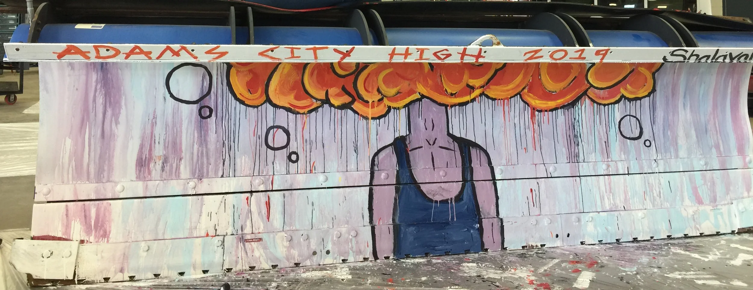 Painted mural featuring a person with an orange cloud above their head, surrounded by thought bubbles. Text reads 'Adam's City High 2019' at the top.