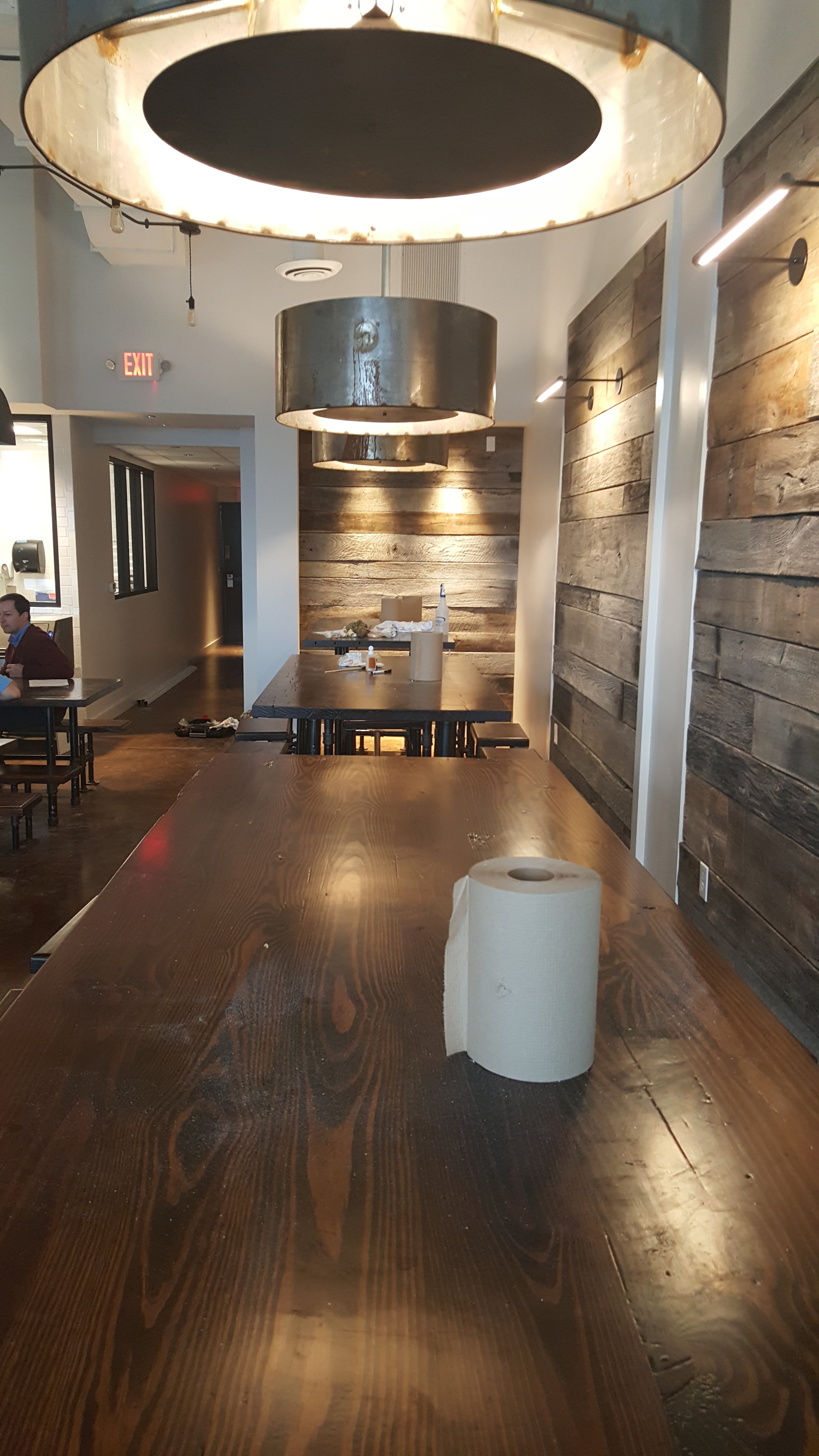  Finding a way to create a more personal space in a public location can be a challenge.&nbsp; This was solved by creating a set of bar-height tables, with large hanging light fixtures that help establish and contain a space within the open floor plan
