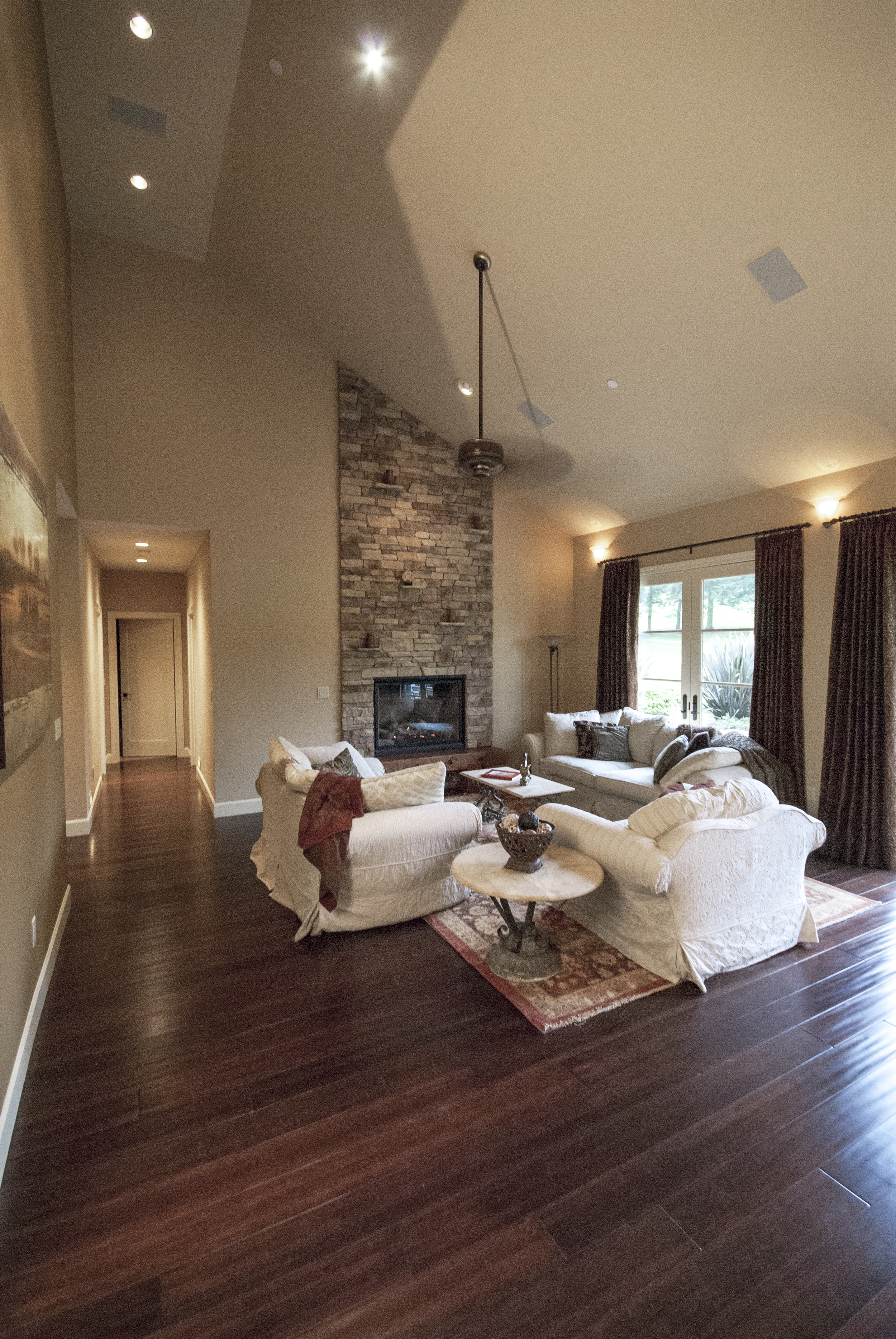 The great room concept is beautifully executed and includes a custom field stone floor to ceiling fireplace and vaulted ceilings.