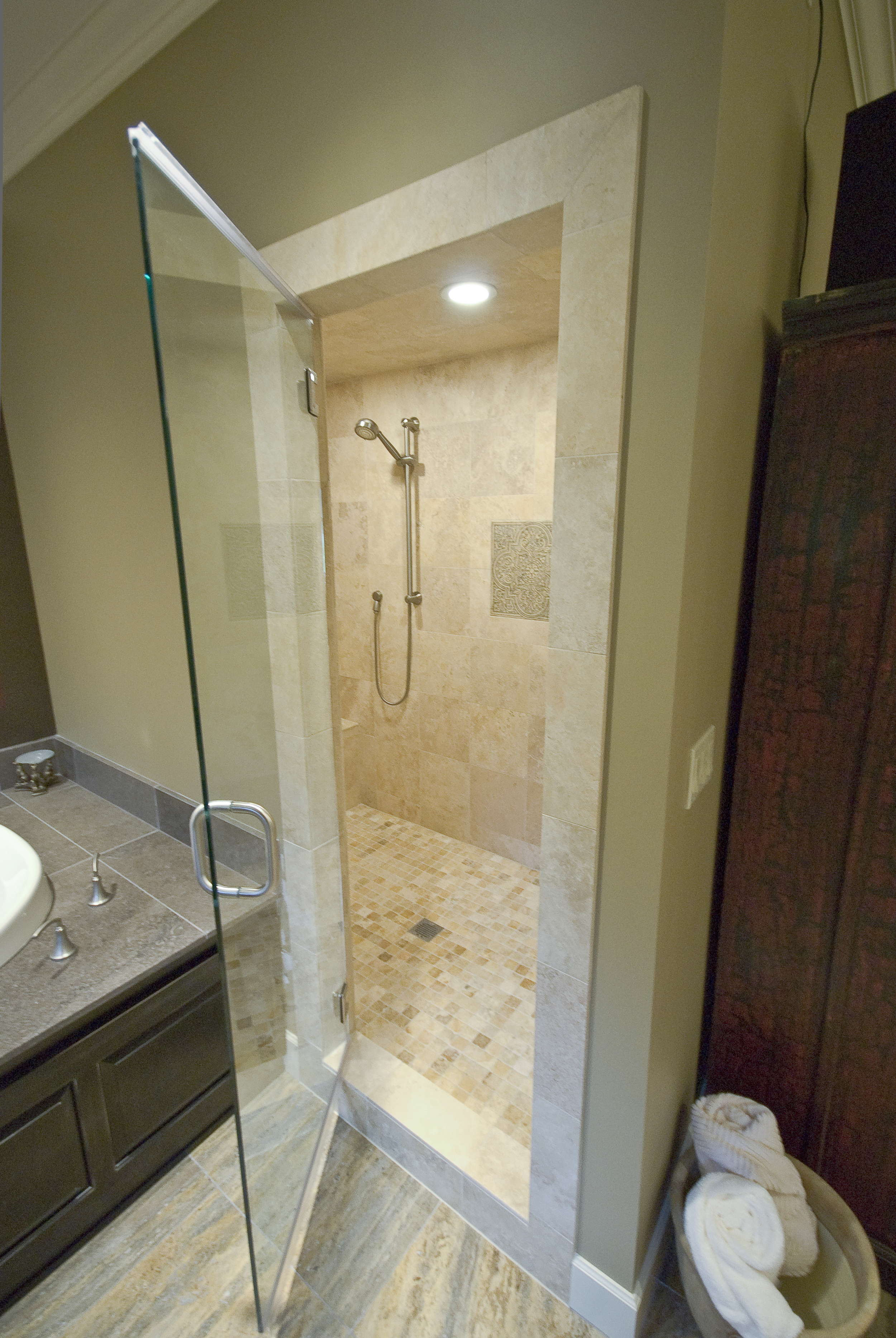 The steam shower was a must for him a sealed room with travertine tile floor to ceiling.  The tile is heated even in the shower and on the bench!