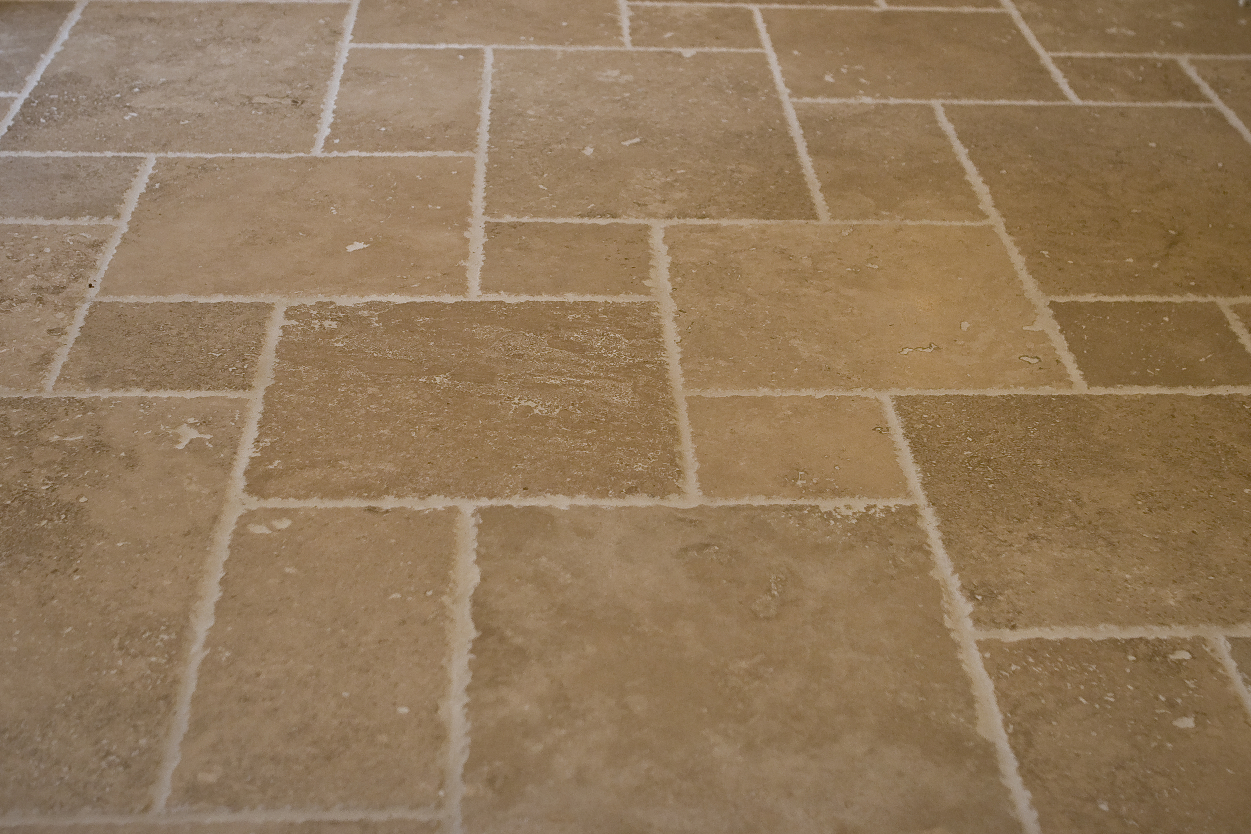 Travertine tile laid in a "pinwheel" pattern.