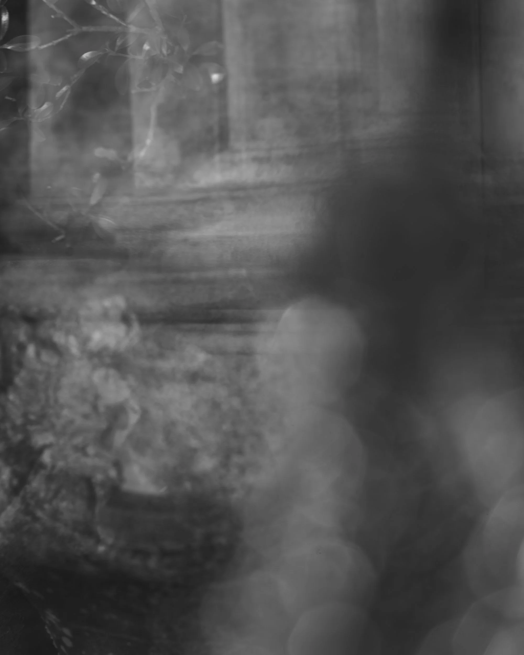 A black and white photo showing a person's hand holding a cigarette close to a burning flame.