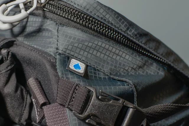 The exit point for the straw from the hydration pocket (bladder not included, but cheap to buy from REI). Notice the big zippers that are less likely to jam up with a little dirt or mud.