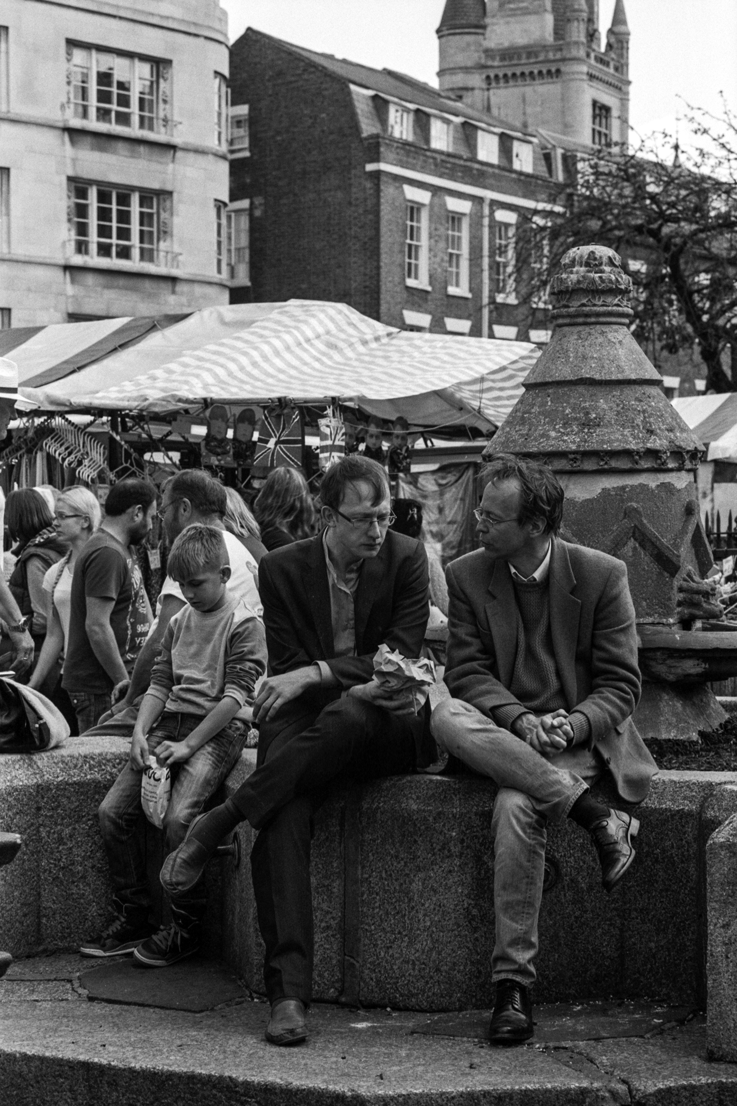 I walked right past these two German men without noticing them until my ears caught them speaking German. Having taken some German in school, I turned to see who the voice was attached to and was immediately captured by them. For me, it's the little boy who looks bored that really makes the image.