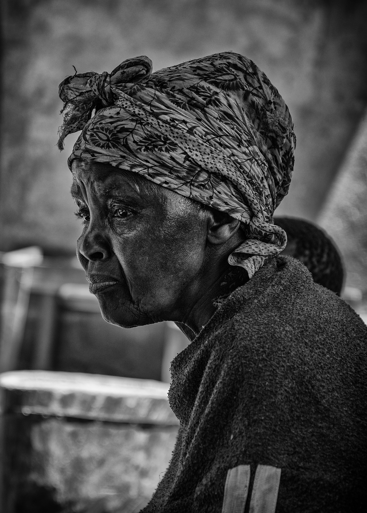 A woman who is probably in her 50's was shucking corn shells by hand while her sons work the coffee farm