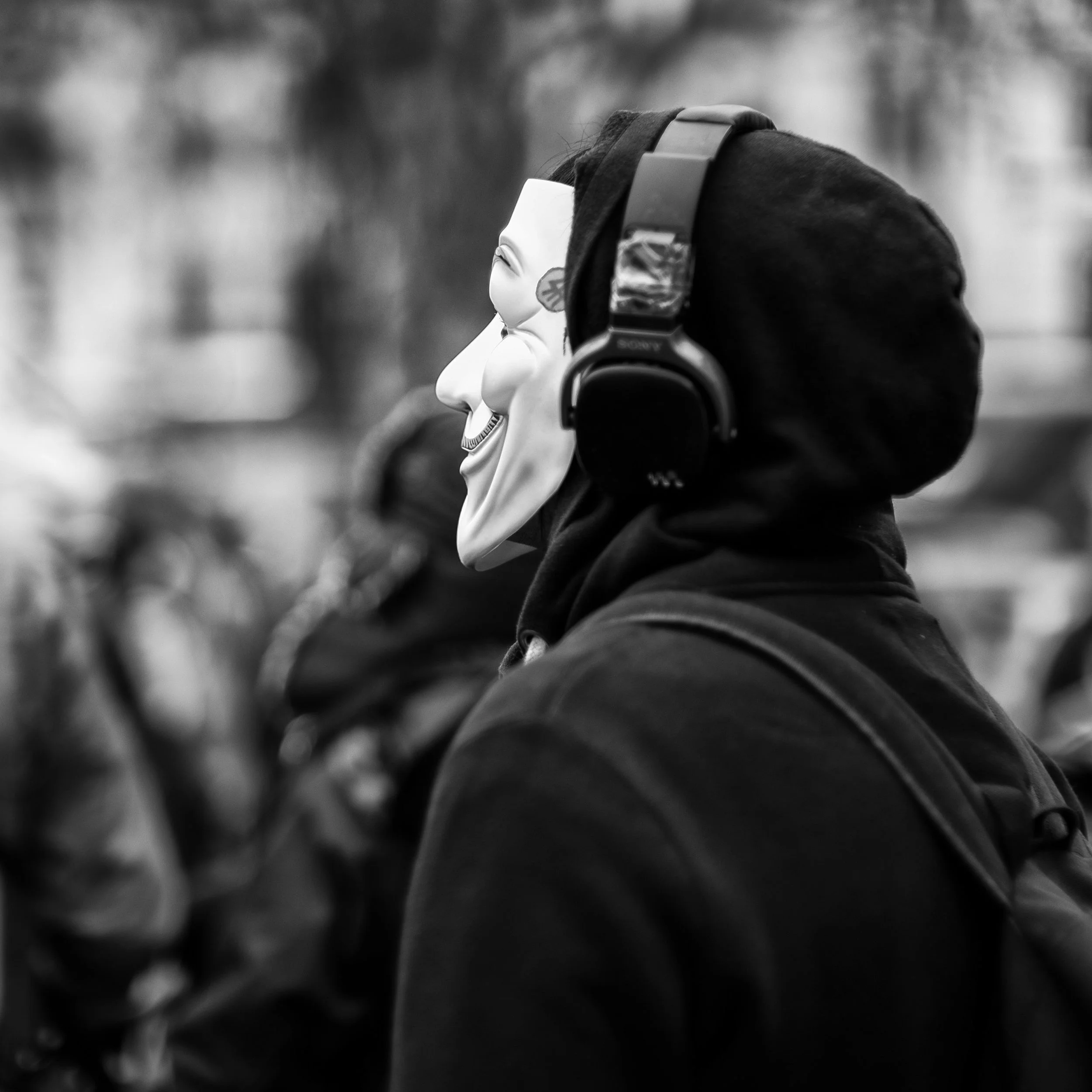 A masked protestor listens to a speaker at the anti-nuclear rally in Trafalgar Square