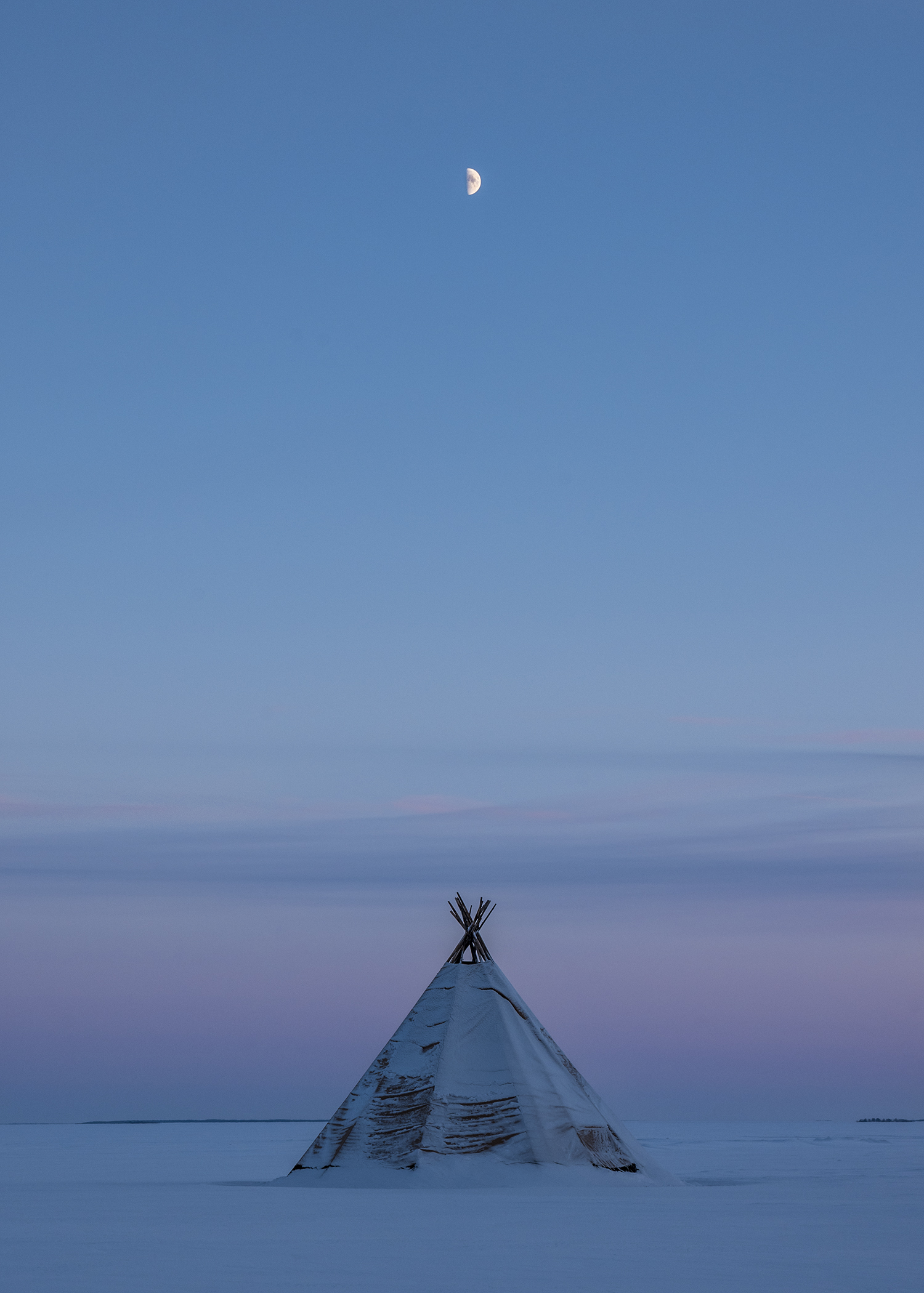 Moonrise over a tent on the frozen archipelago of Swedish Lapland.