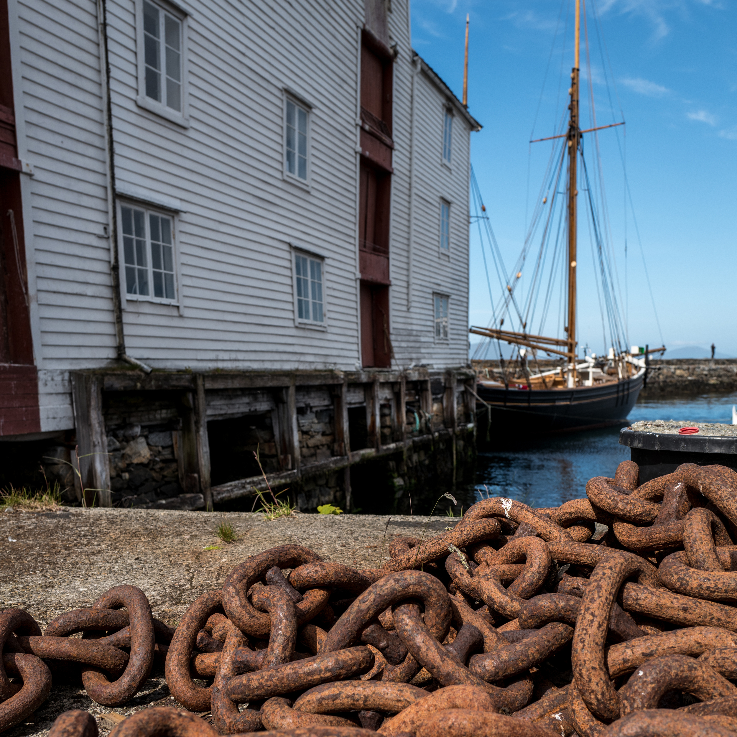 Some rusted chain lays abandoned in a dockyard along the canals of Alesund, Norway