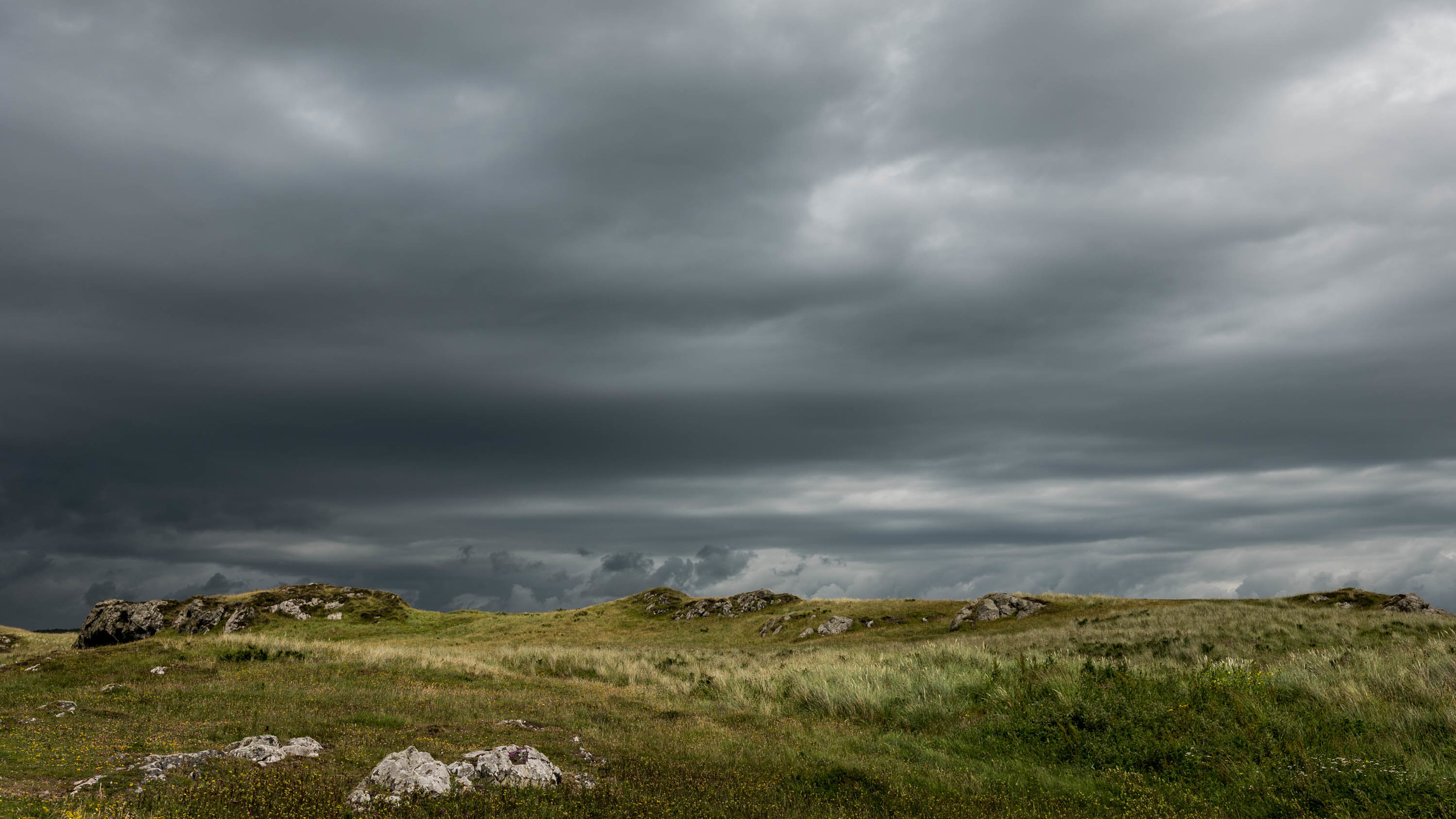Dark storm clouds approach over Llanddwyn Island