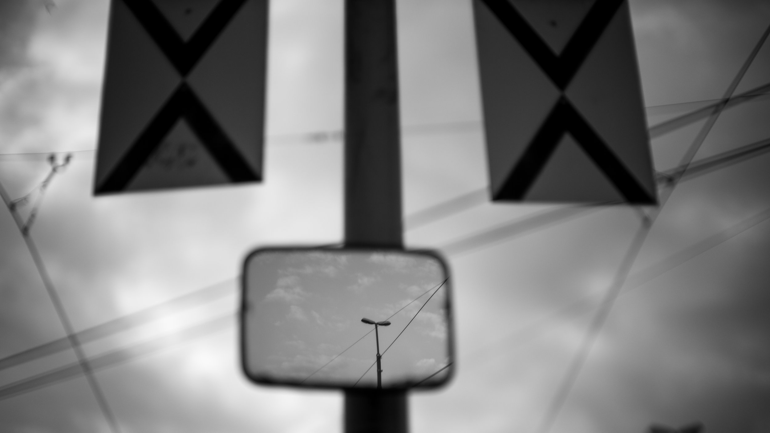 This is a bit of a surrealist image - a photograph of a light pole with a reflection of a light pole