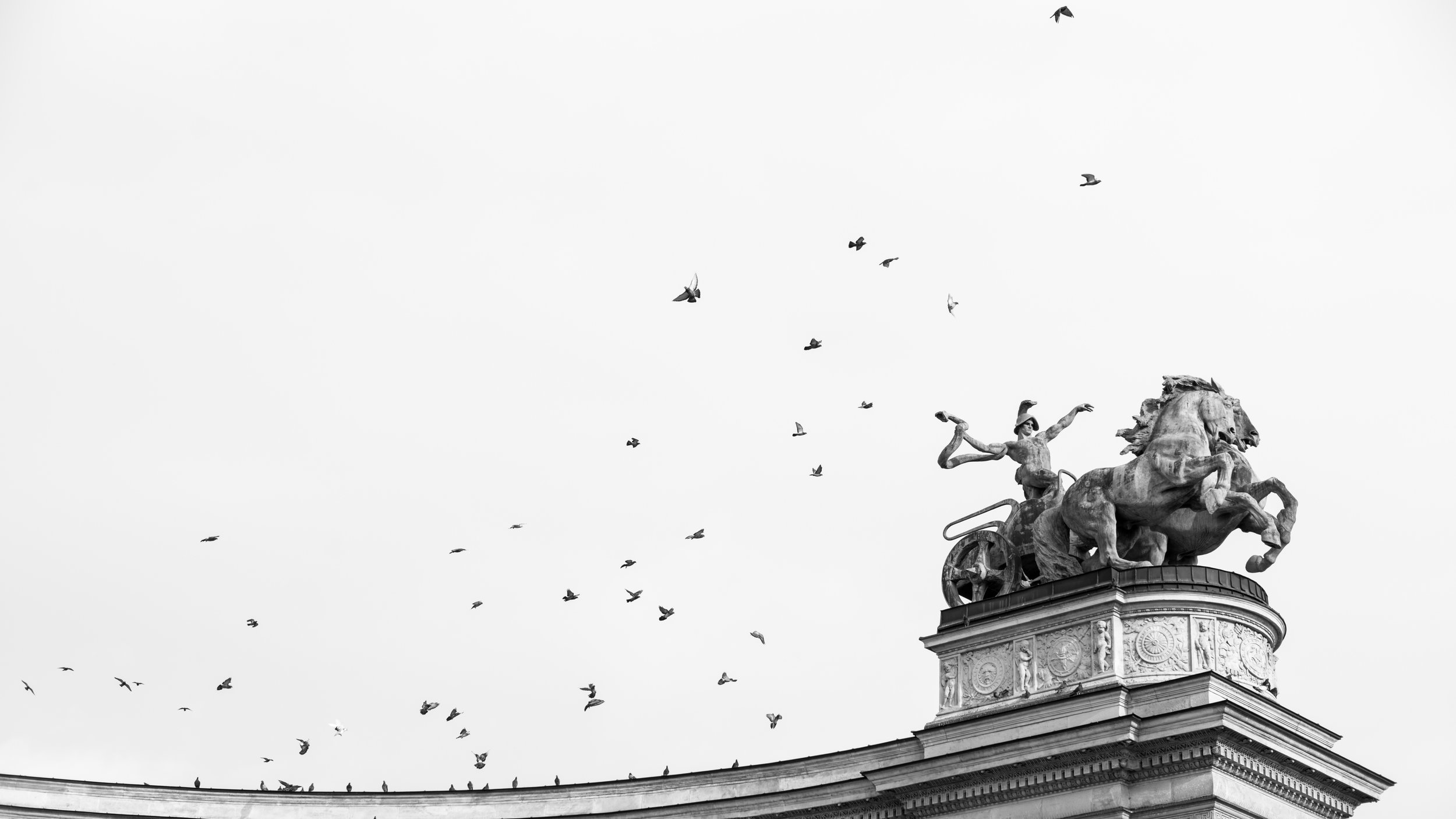 Everyone else in the Hero's Square of Budapest was photographing the monuments. I was pre-focused and pre-composed waiting for the birds to take off. After a few long minutes of pigeon watching, they finally jumped into flight. Best yet - their flight path worked perfectly with the direction that dude in the statue was pointing. Winning!