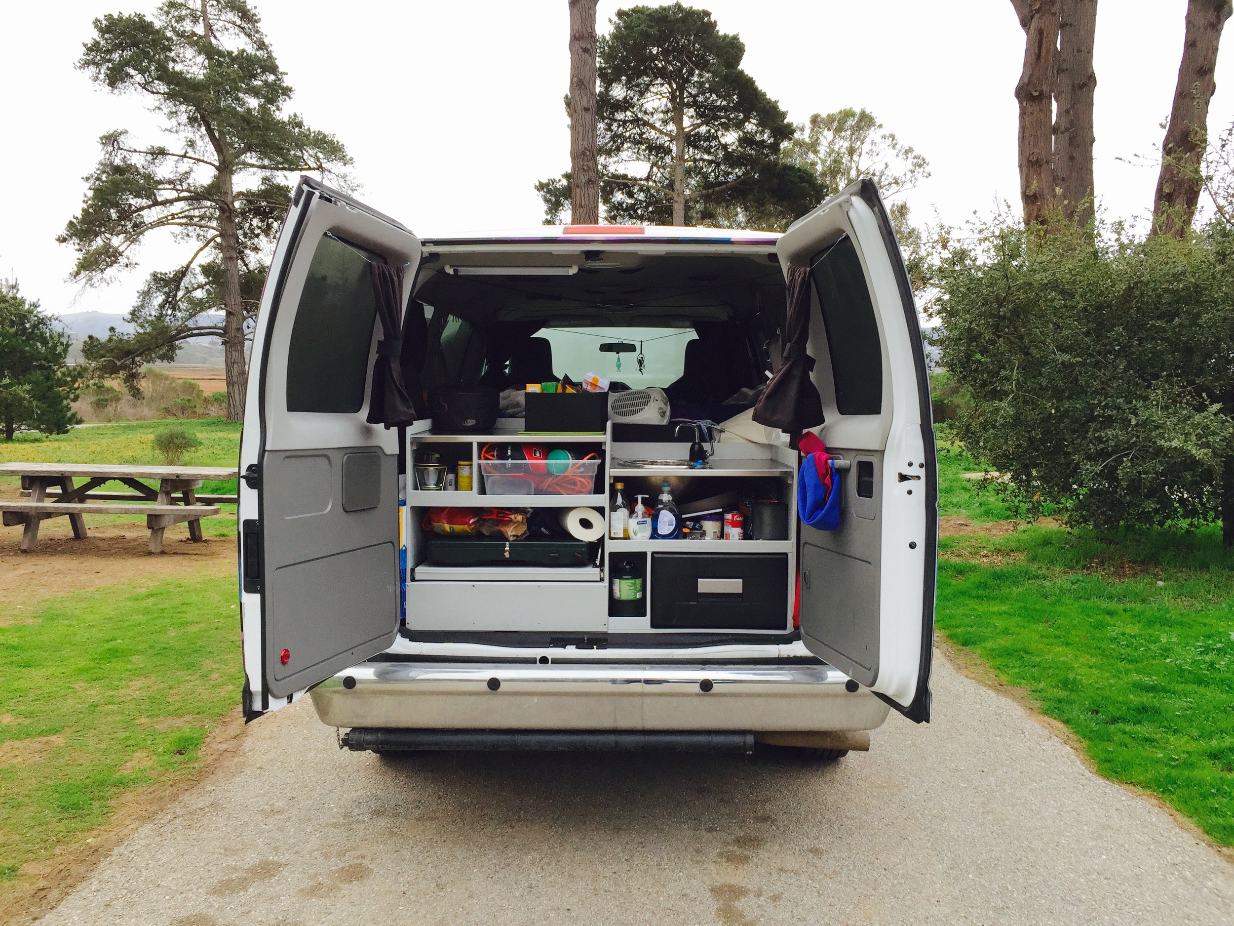 The back of the van opens to reveal the kitchen area. The bottom right drawer is a small fridge. There is a stove on the left side.