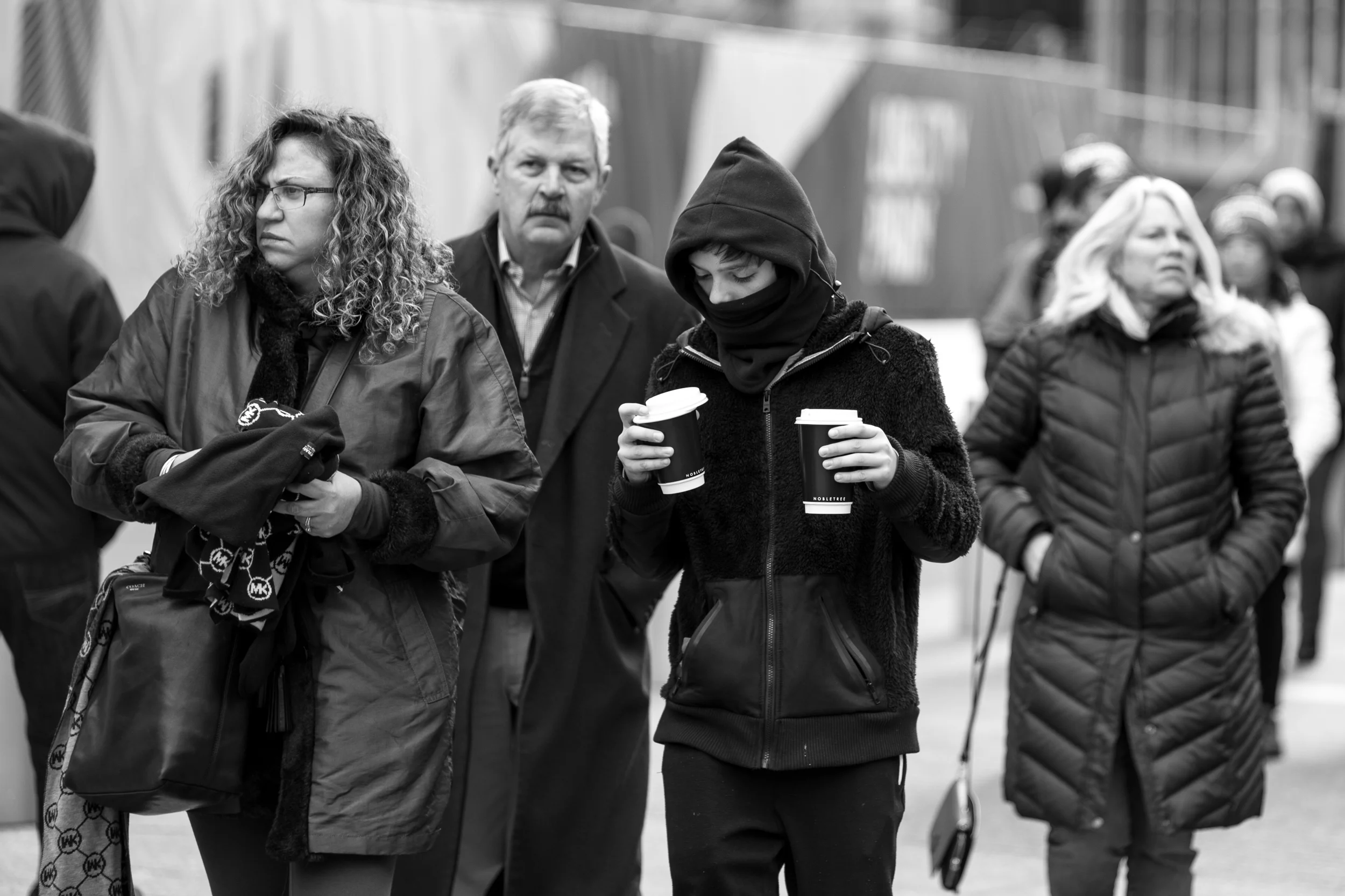 Coffee Jolt. A kid carries two cups of coffee while walking with his parents around the 9/11 memorial. Leica M10 with 90mm Summicron f/2.