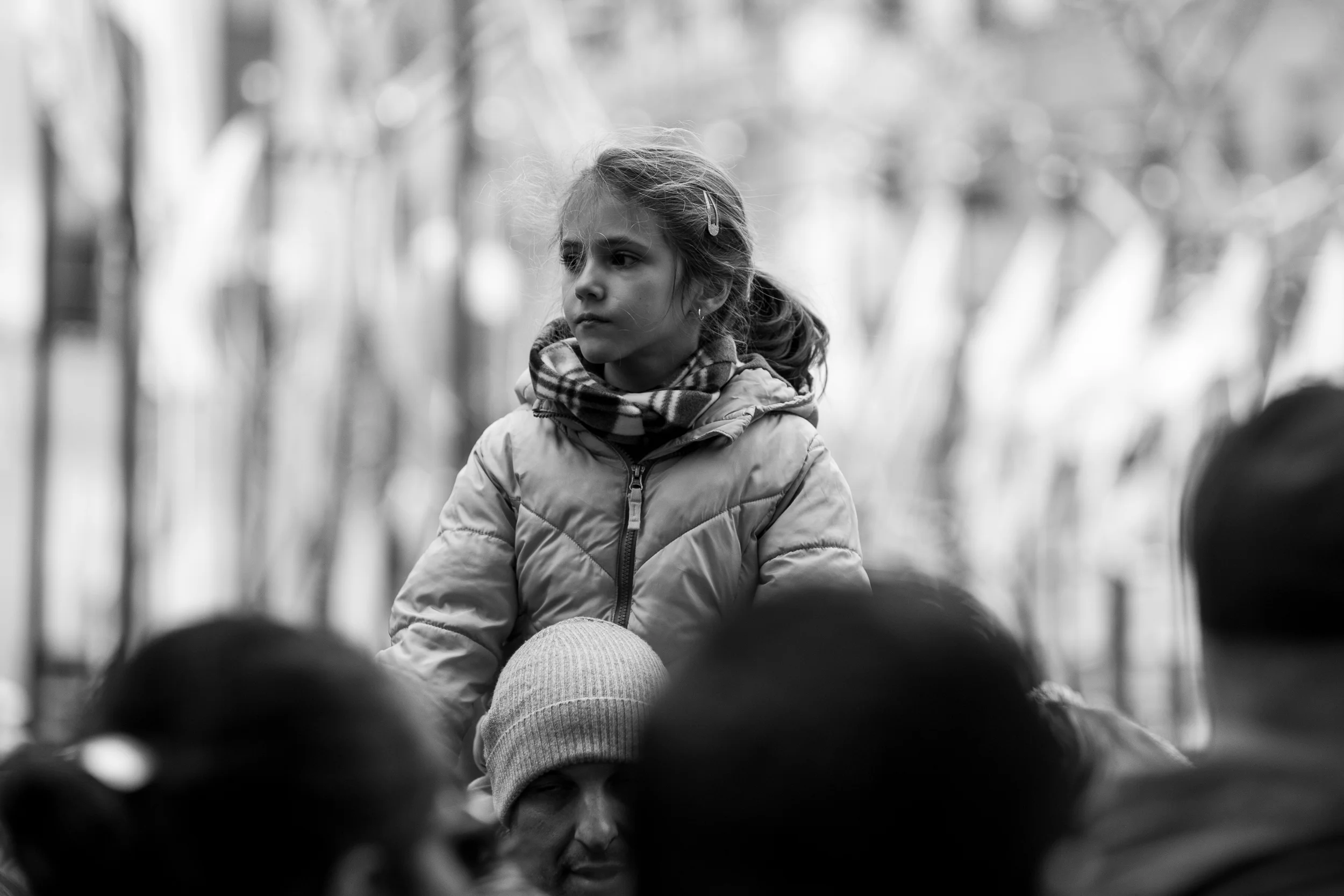 Catching a ride. A young girl rides on her father's shoulders over the crowds of tourists visiting Rockefeller Center during the holidays. Leica M10 with 90mm Summicron f/2.