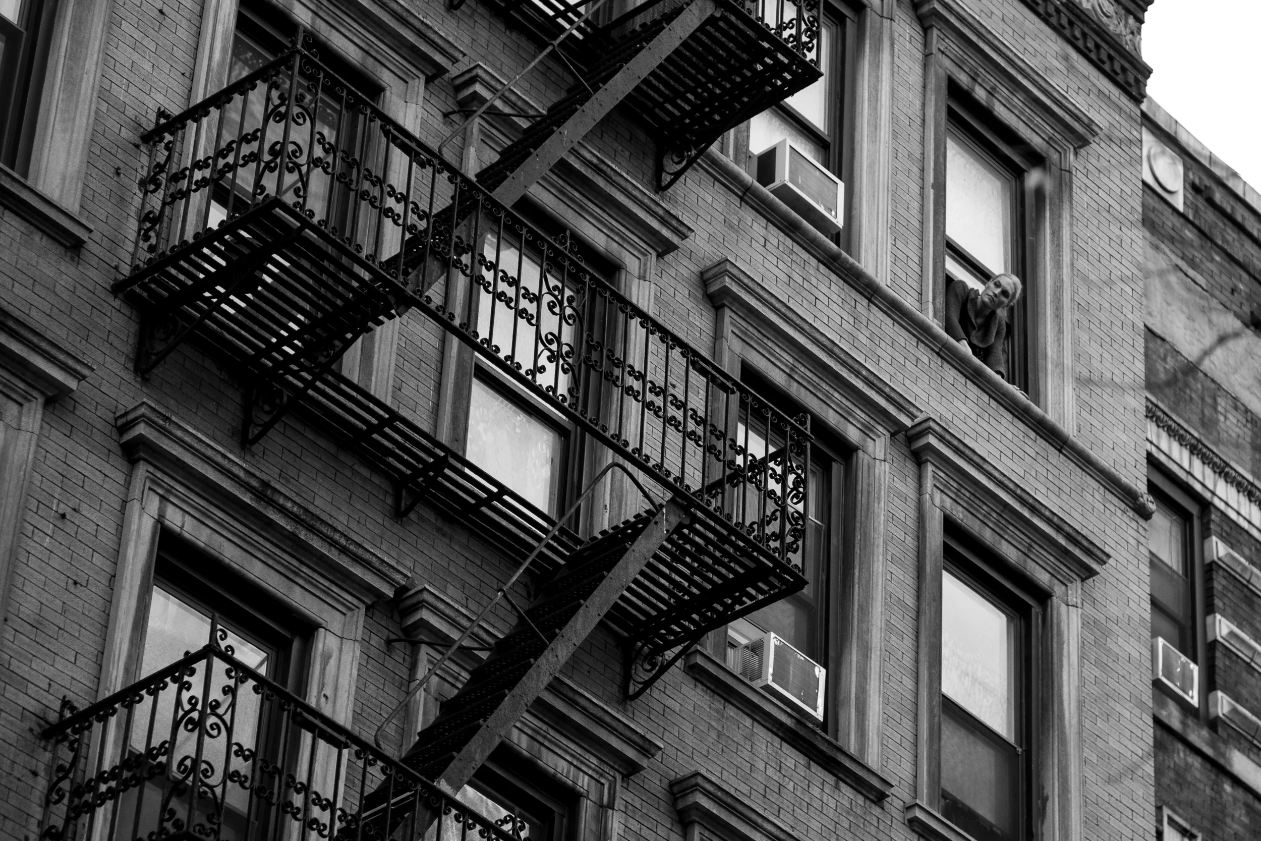 I spy. A woman looks out from her window on the busy New York streets below. Leica M10 with 90mm Summicron f/2.