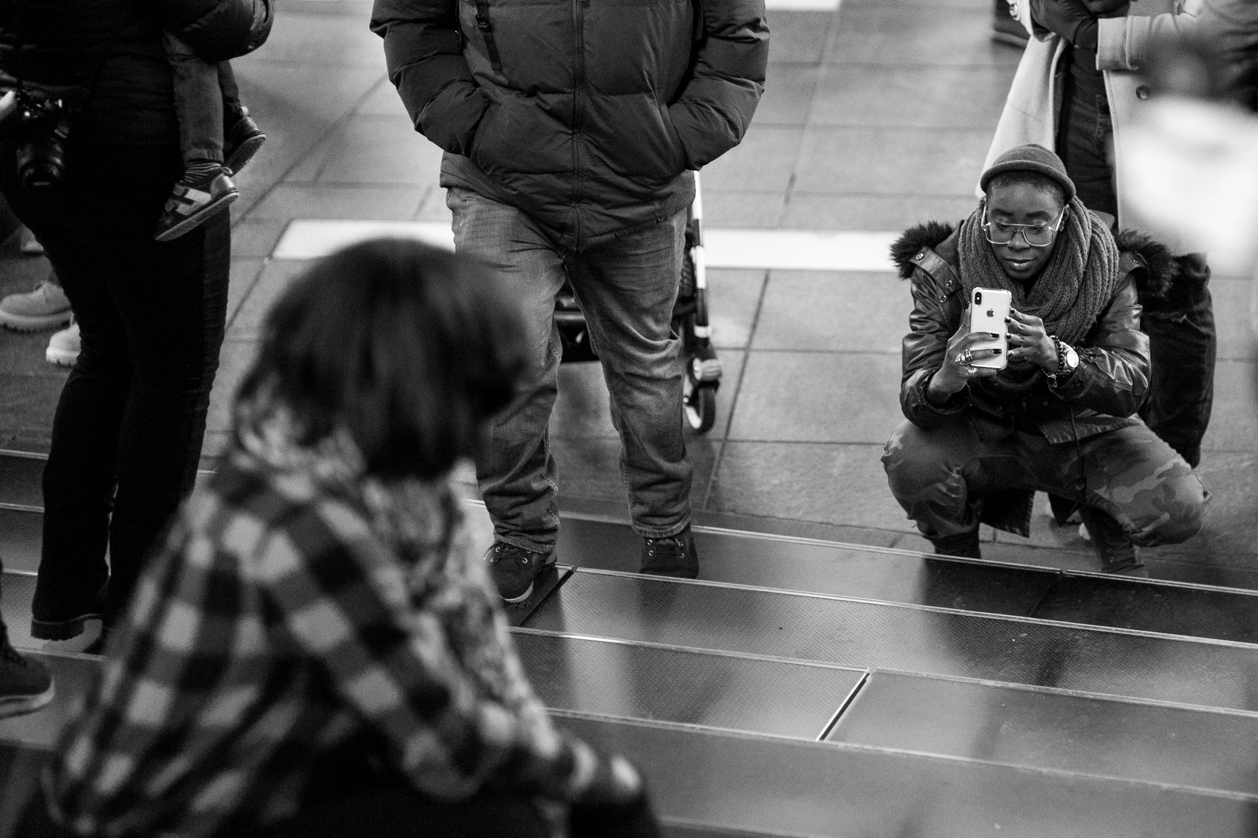 Steps of Time. Two friends take pictures on the staircase in Times Square. I loved the attire and face of the individual holding the cell phone, so focused the attention of the viewer that direction by having the rest of the image slightly out of focus. Leica M10 with 90mm Summicron f/2.