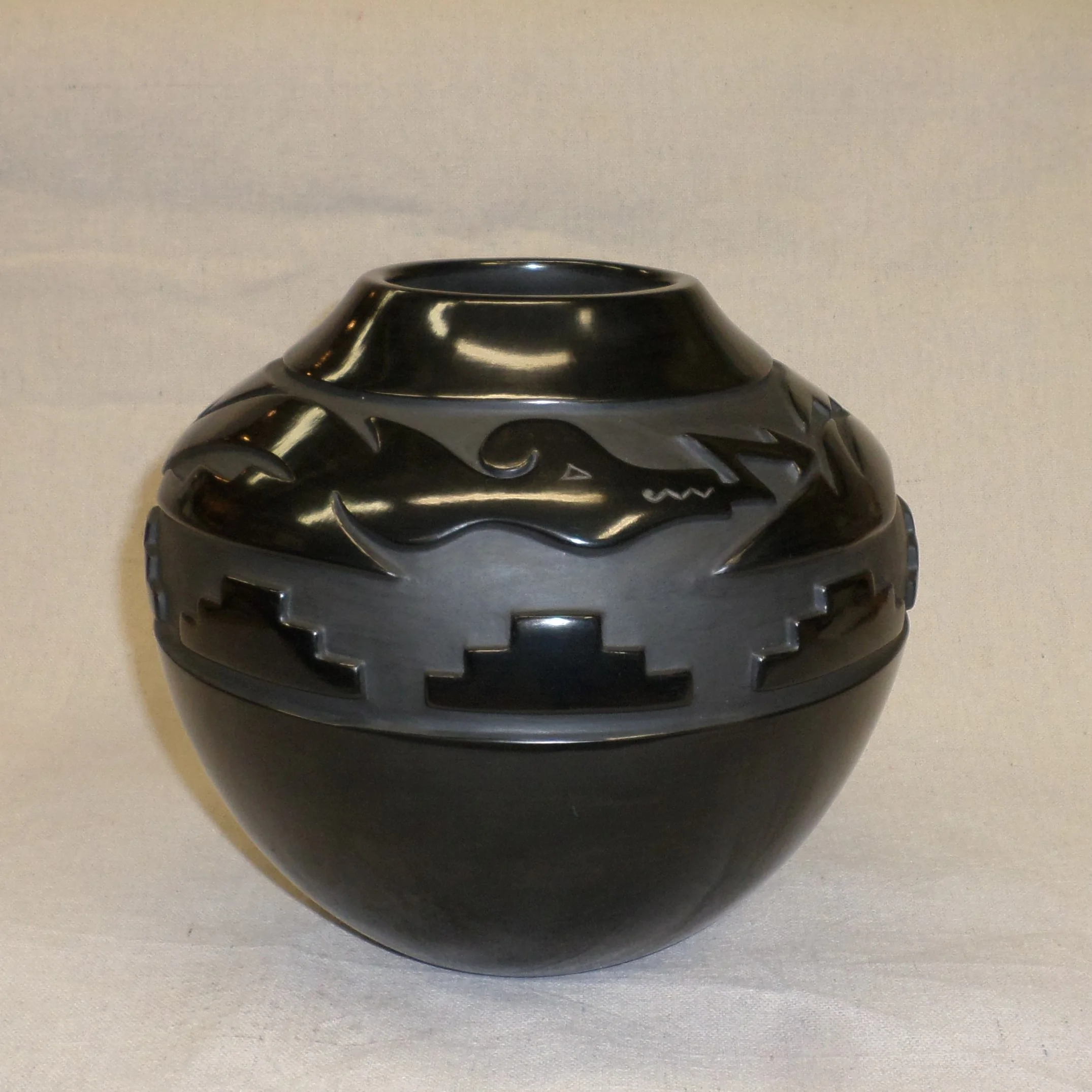 Black deep carvedtraditional storage jar with Avanyu and Kiva step designs 8-1/" H x 9-1`/8" Dia. SOLD 