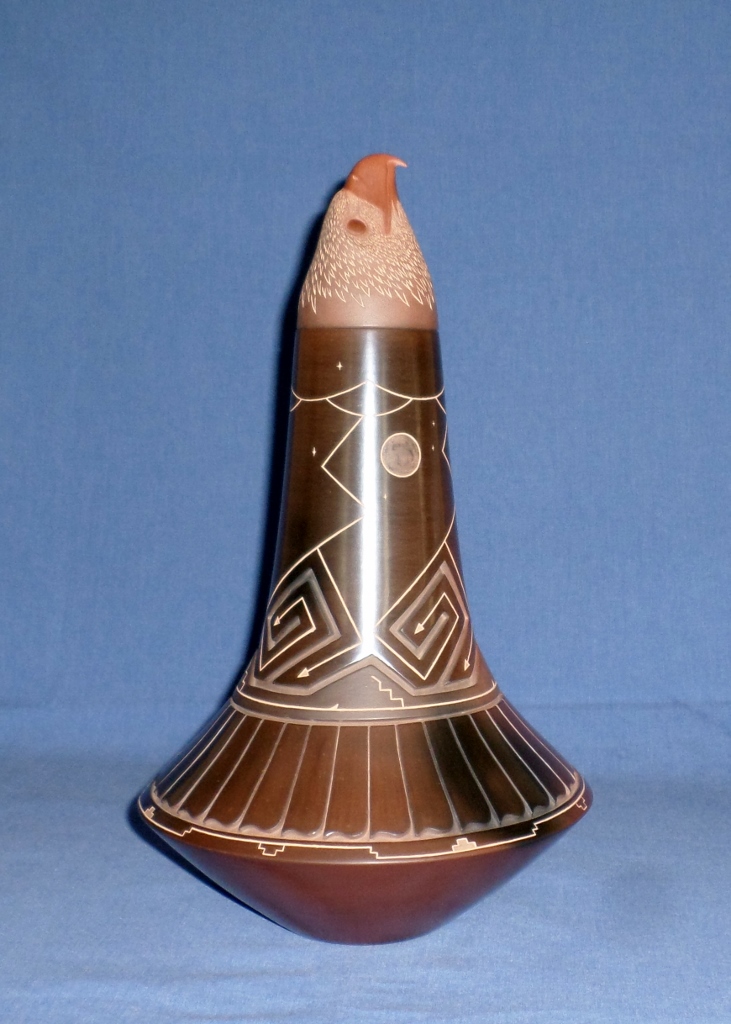 Brown Eagle Jar with deep carved Mountain Peaks, Walking Bear Paw and Feather Designs. Etched Designs include Clouds, Lightning. Stars, Mountain Stream, Kiva Steps, Water and the Moon. 14-3/4" H X 8-5/8" Dia.