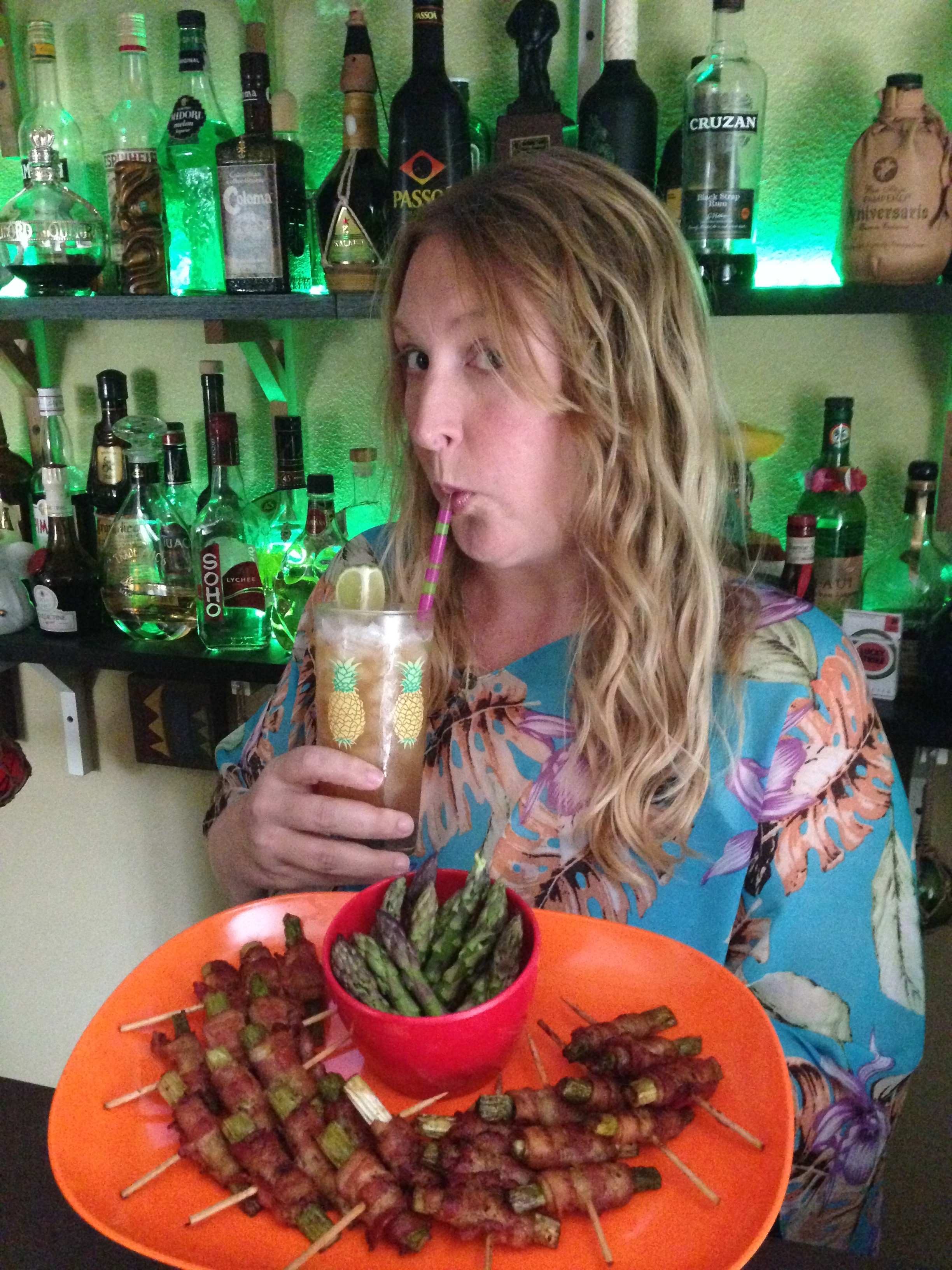 Kalani is enjoying a Ballast Point Mai Tai while showing off bacon wrapped asparagus. 