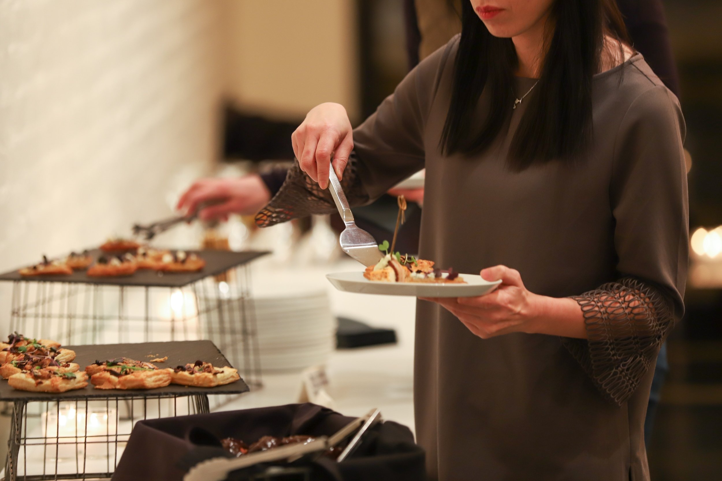 Woman serving herself food at the event space.jpg
