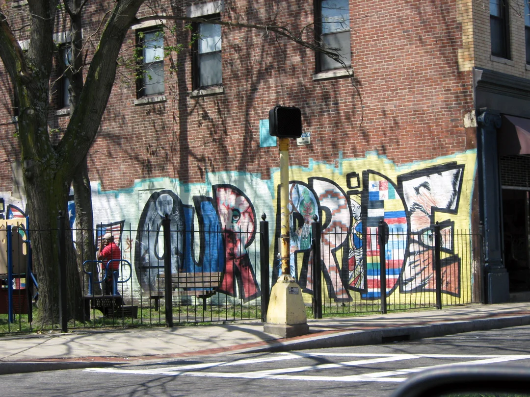 The green house in the first image above was constructed as part of a larger neighborhood civic initiative to engage residents in the transformation of public space, including the mural in this image, which is down the street from the green house. Source: Matt DelSesto.
