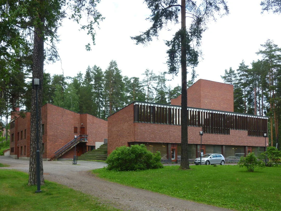 View of the Town Hall from the south, with the offices and residences to the left, the public library with the large windows in the middle, and the vertical tower of the council chamber in the background. Between the office / residential block and the public library are grass-covered steps spilling out from the garden courtyard. Source: Aseem Inam.