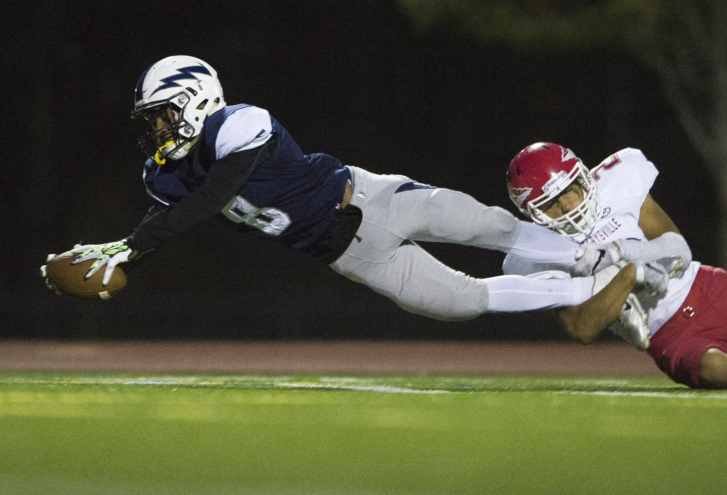  Squalicum's Damek Mitchell dives toward the end zone with Marysville-Pilchuck's Keith Pablo hanging from his legs to score a touchdown on Friday, Sept. 16, at Civic Stadium in Bellingham. 