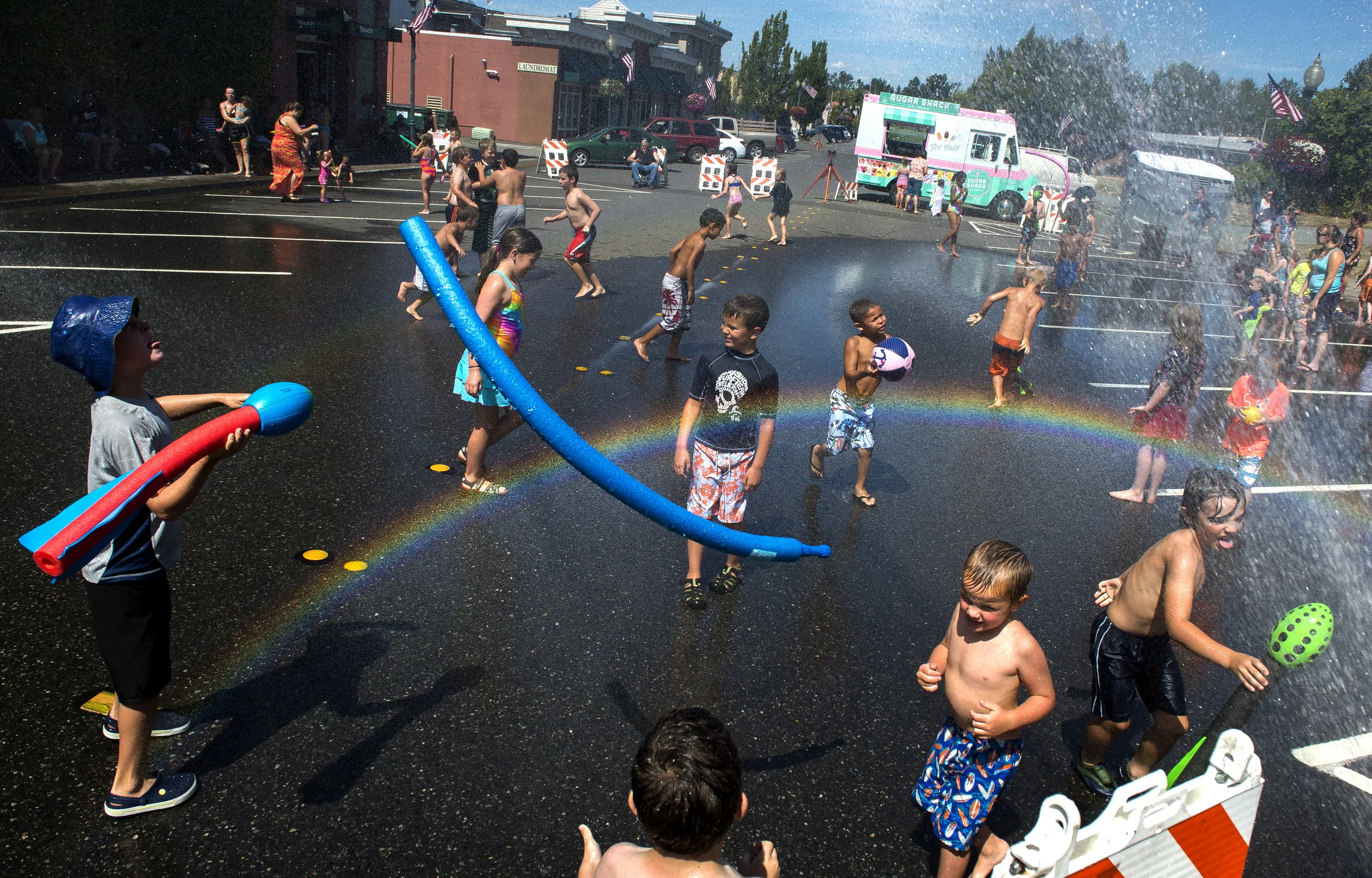  Children play in the water spray along Third Street at Splash Days on Friday, Aug. 12, in Blaine.&nbsp; 