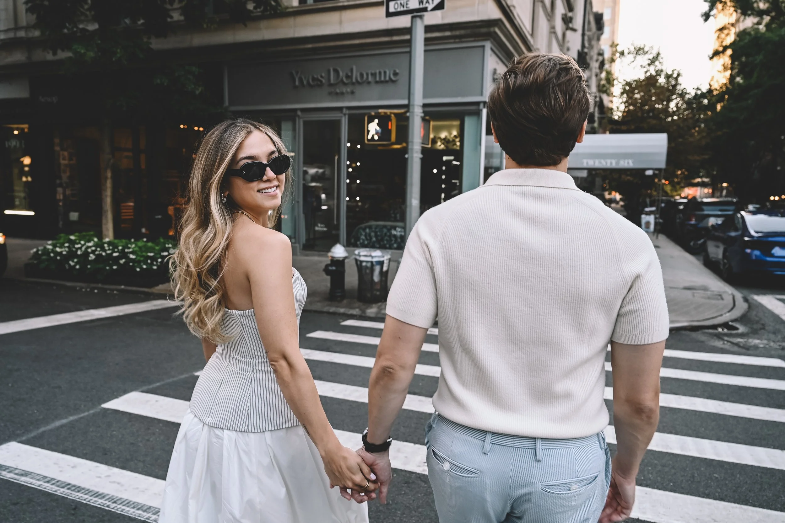 Upper East Side engagement session featuring a couple holding hands on a Manhattan street corner, captured in a natural documentary style by NYC engagement photographer Robert Carlo.