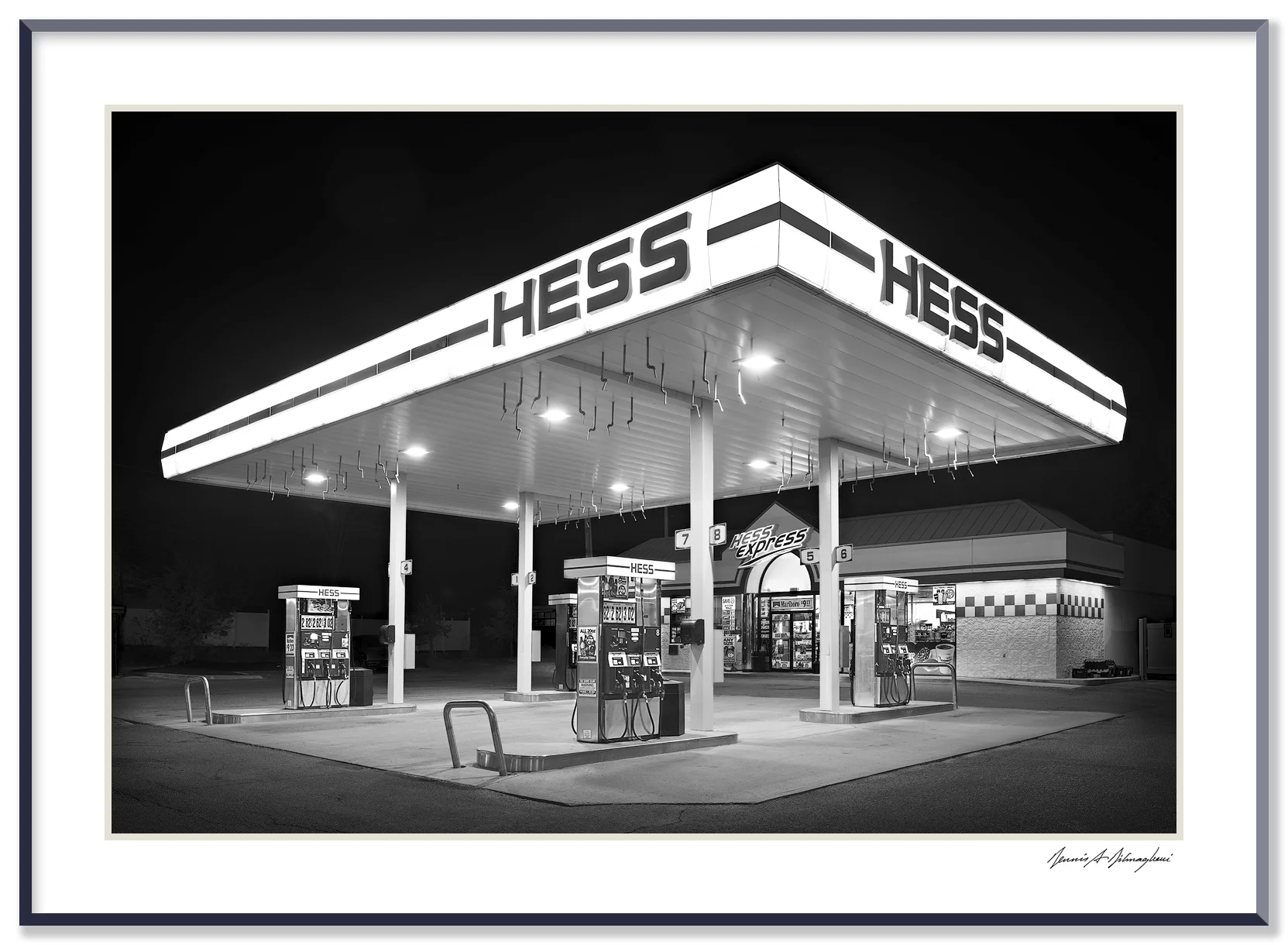 Hess Gas Station - Hudson, NY This recent Hess Gas Station provides a wonderful contrast to the image of Mora Valley Oil Co. taken many years before. The two photographs must be appreciated side by side. Same merchandising concept, different era. In this image the stark, monolithic structure towers over a spotless concrete pad and the emptiness gives the scene a stage like appearance.