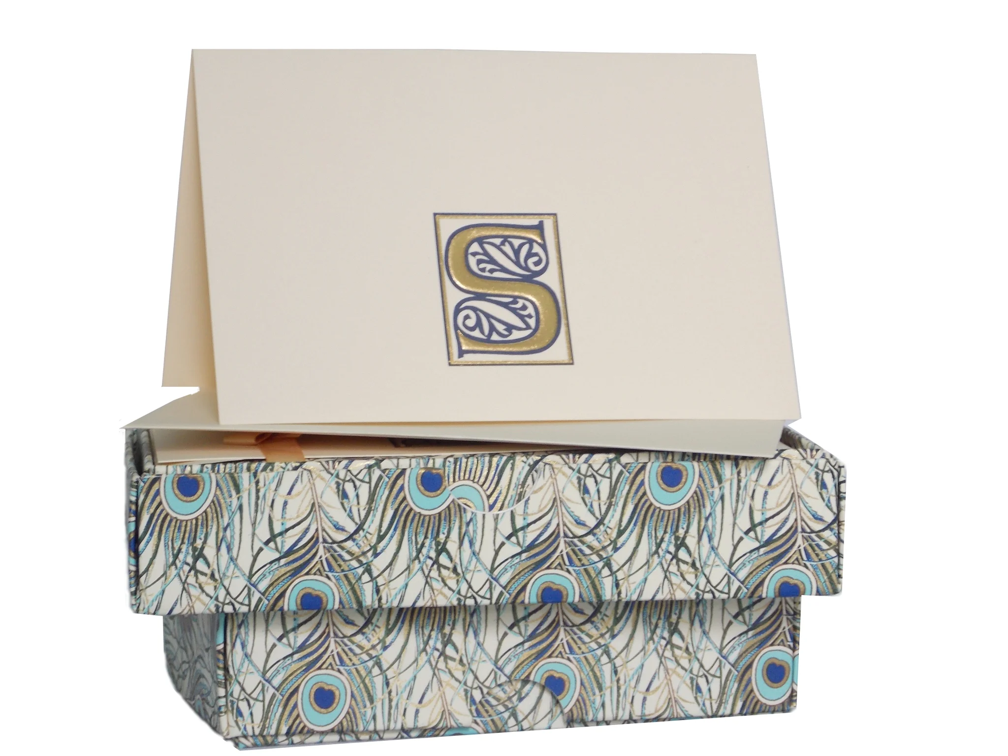MONOGRAM BOXED STATIONERY SET   10 Cream folded cards featuring gold foiled letter.  10 envelopes lined in peacock feather design  Size: 8.5cm x 13cm