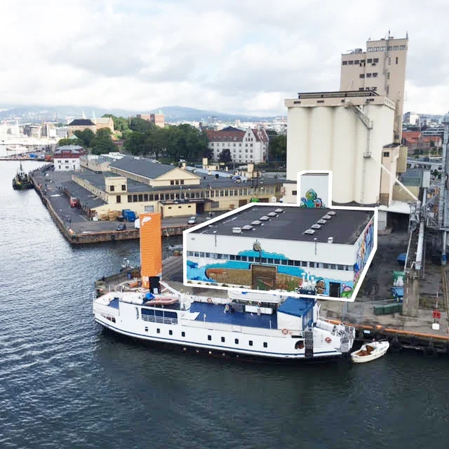 Vippa sett fra danskebåten. Bak ser vi siloen, fiskehallene, og kontoret til Snøhetta på Vippetangen. Rendering: Superunion arkitekter