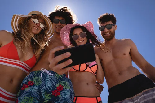 Copy of Group of friends taking selfie with mobile phone at beach in the