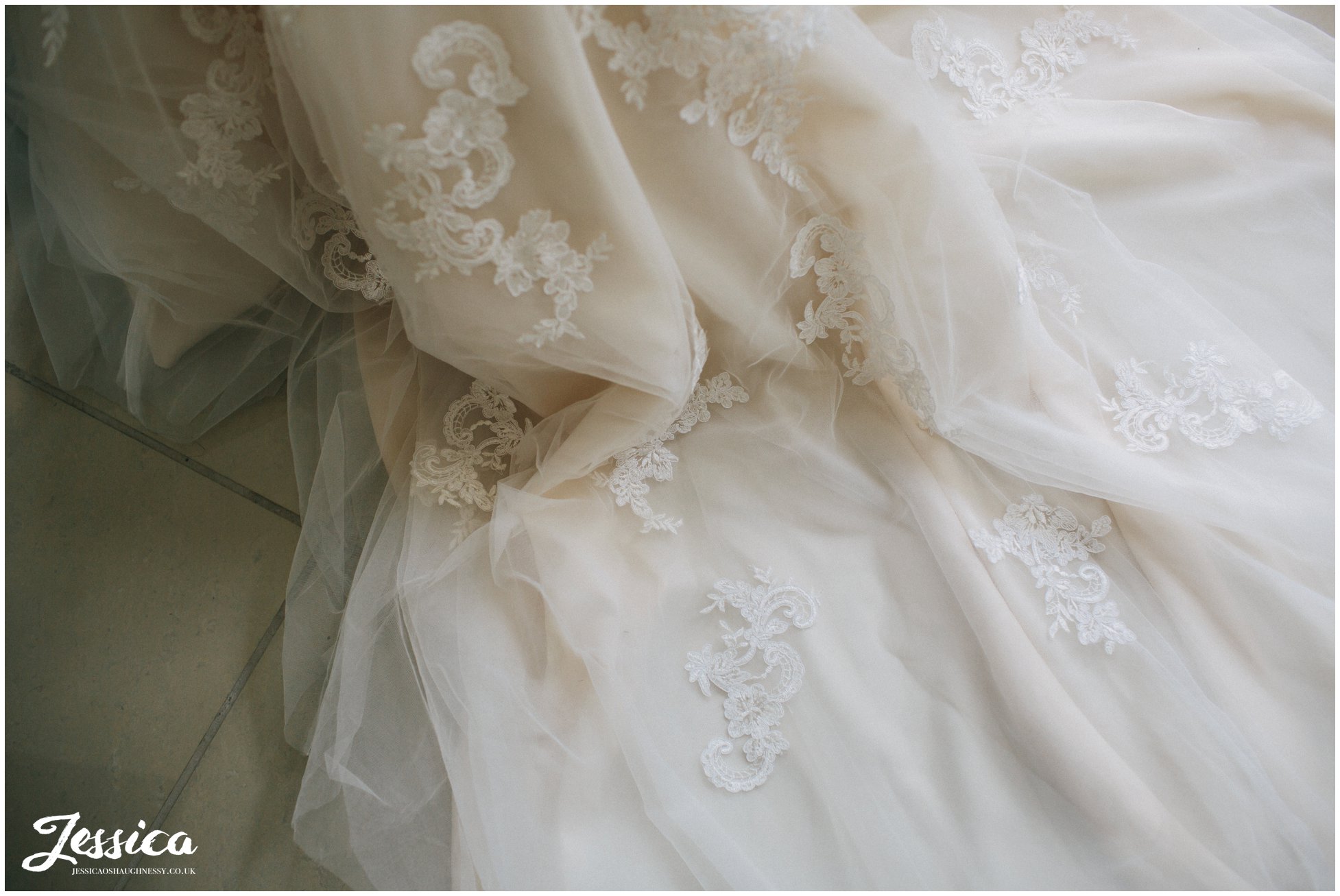 close up of lace detail on the train of the wedding dress
