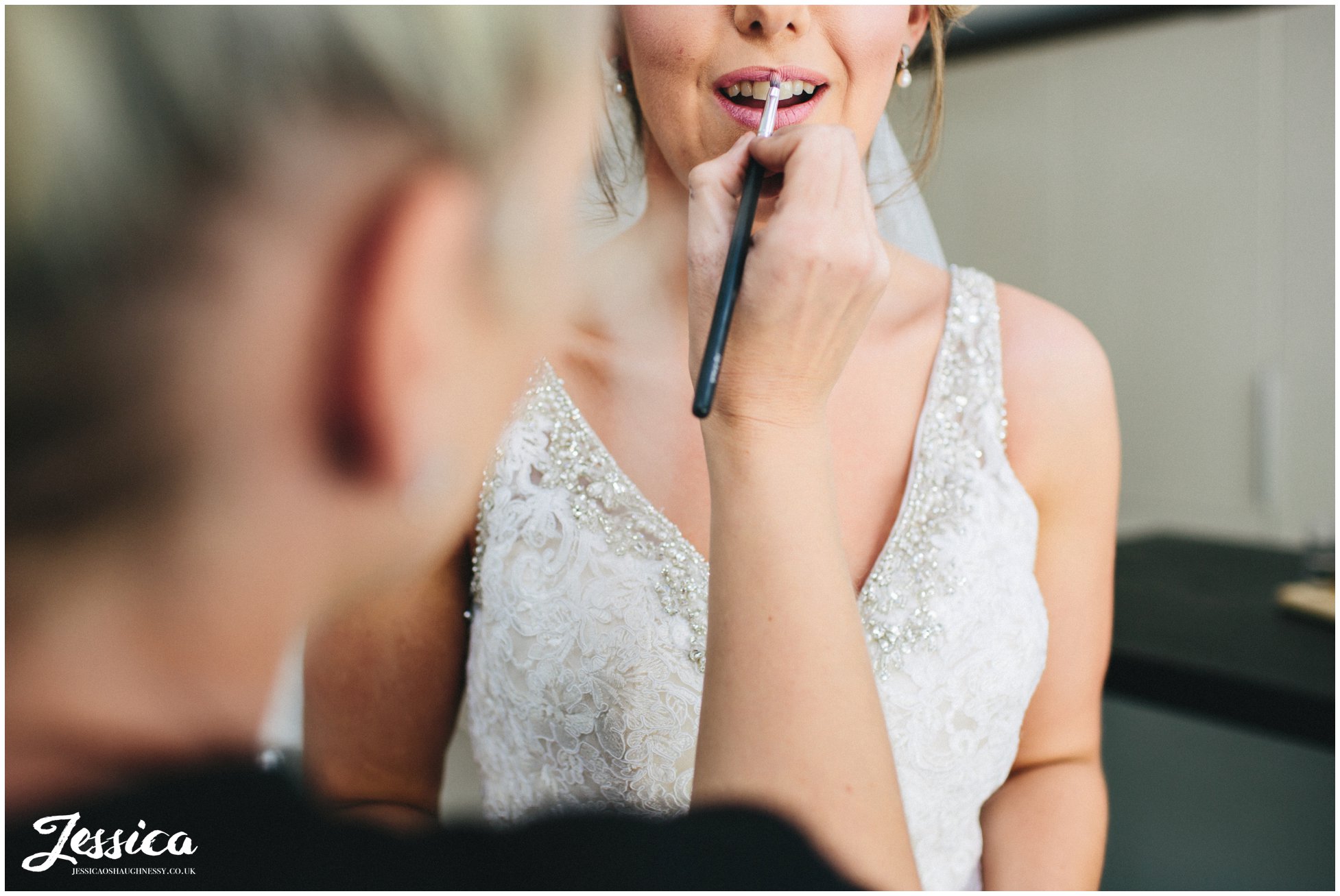 the brides lipstick touch ups before leaving for her ceremony at tower hill barns